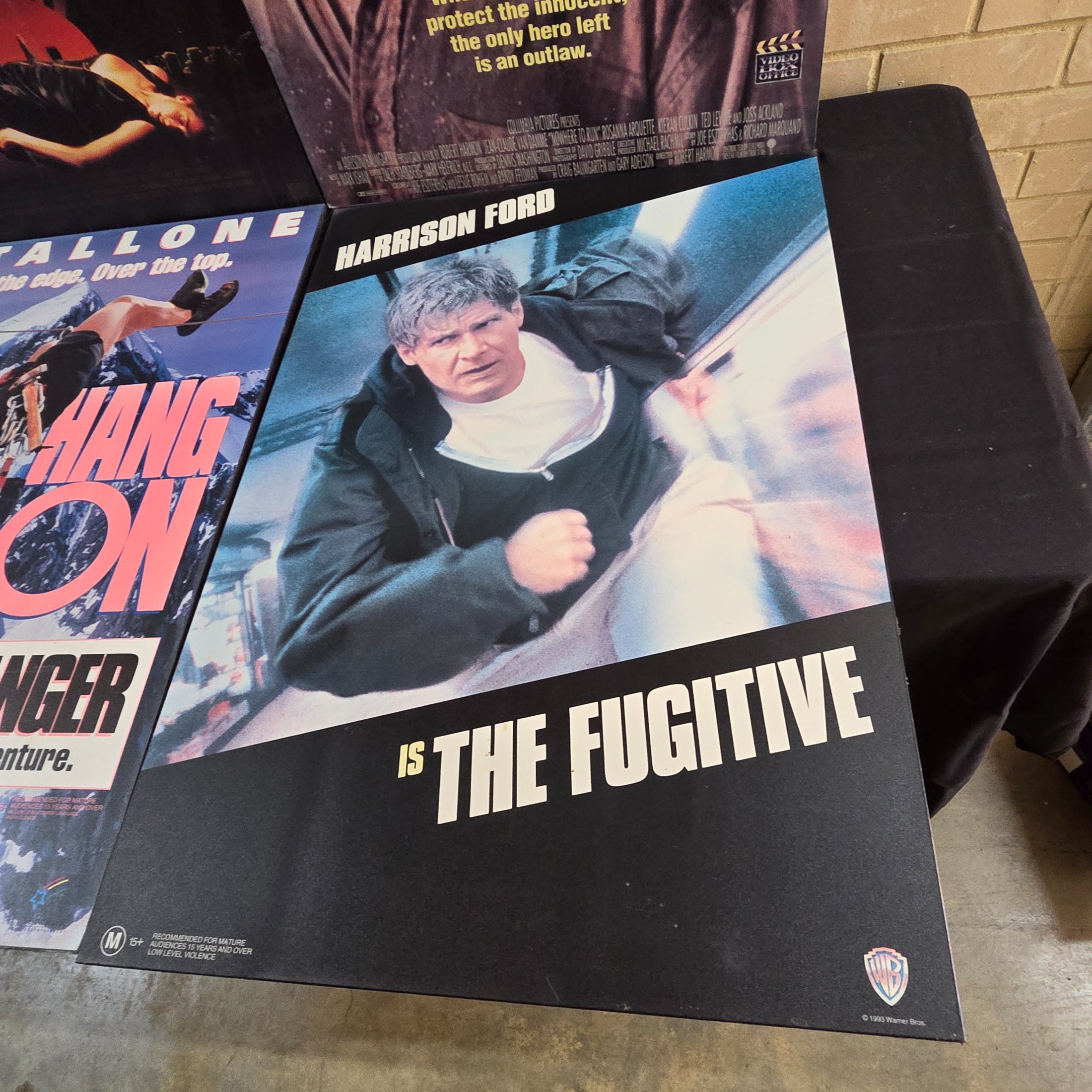 Four mounted original movie posters from the early 1990s, featuring classic action films 'Rising Sun', 'Nowhere to Run', 'Cliffhanger', and 'The Fugitive'. - View 4