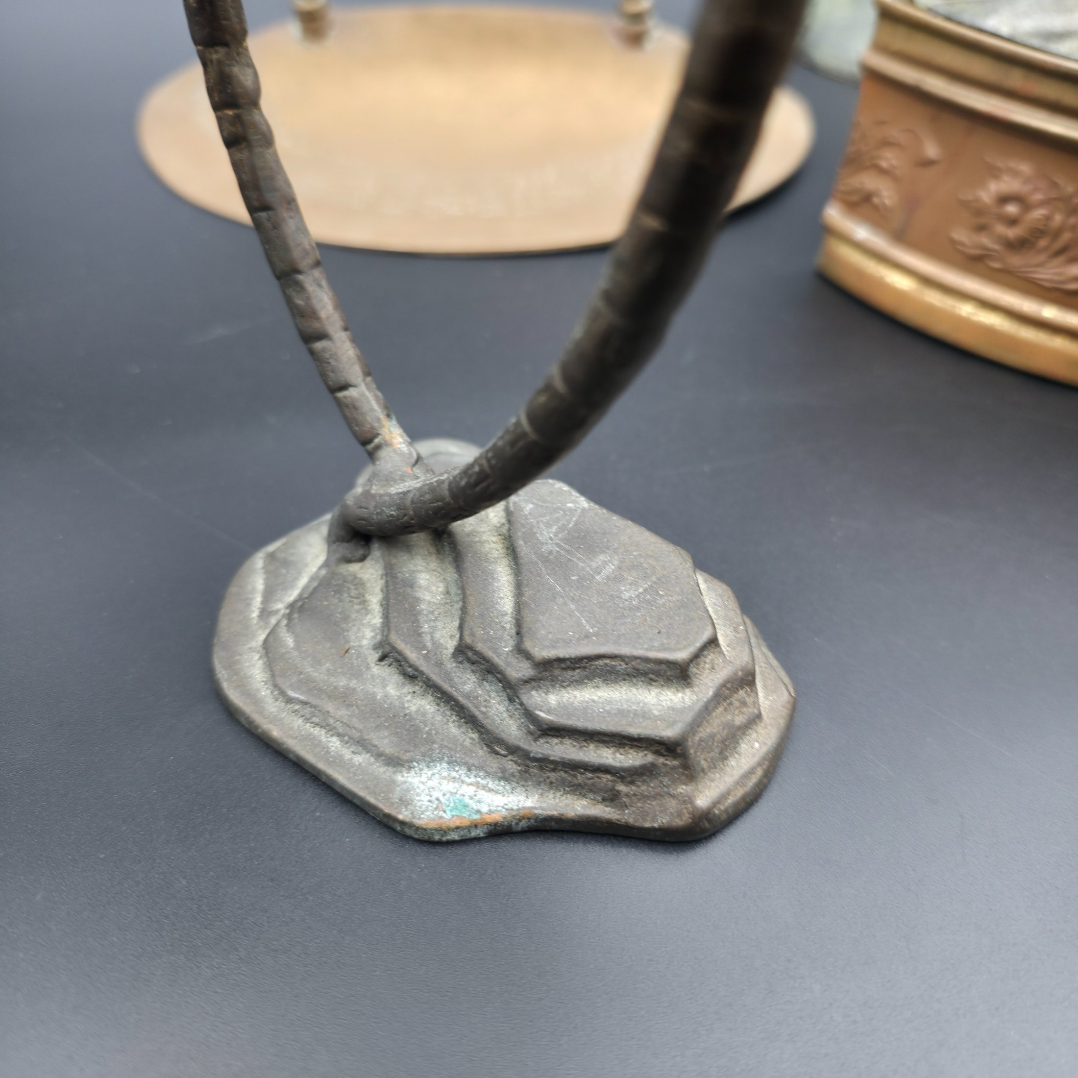 A varied collection of vintage metal decorative items including two palm tree-shaped candle holders, a tall candlestick, a curved display stand, and a wall-mounted brass matchbox. - View 4