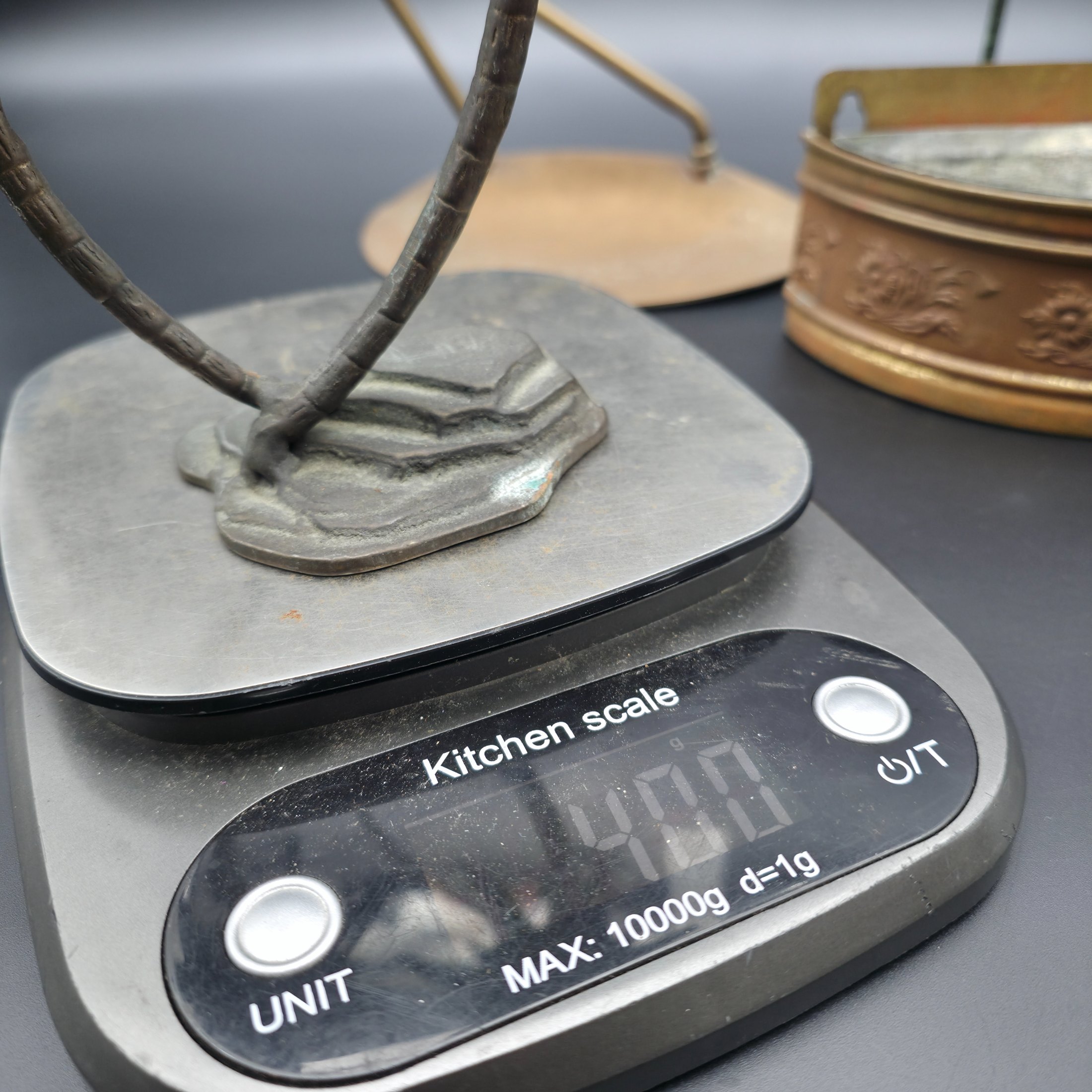 A varied collection of vintage metal decorative items including two palm tree-shaped candle holders, a tall candlestick, a curved display stand, and a wall-mounted brass matchbox. - View 5