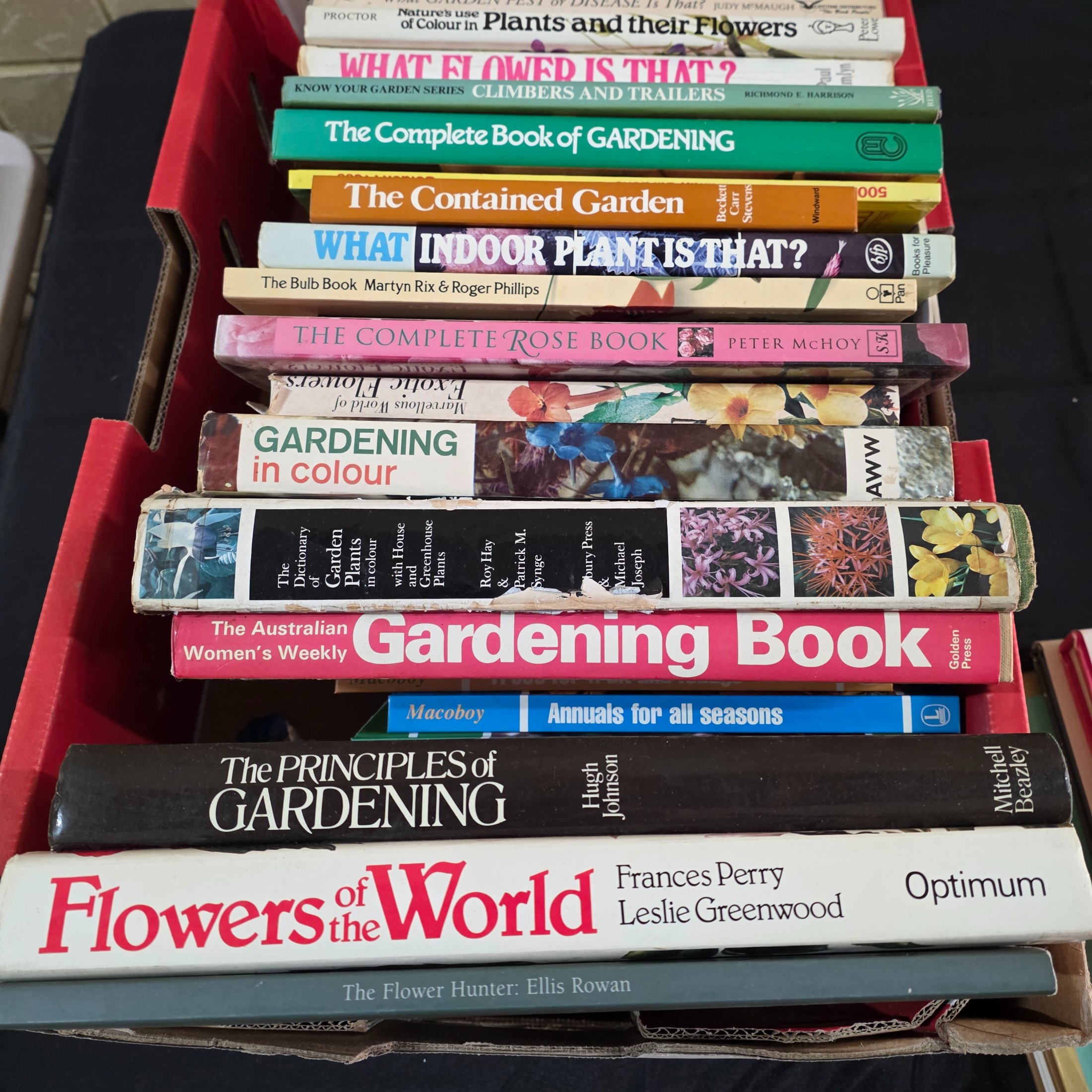 A box containing approximately 20-25 assorted gardening books, including titles on flowers, plant identification, and general horticultural practices. - View 6