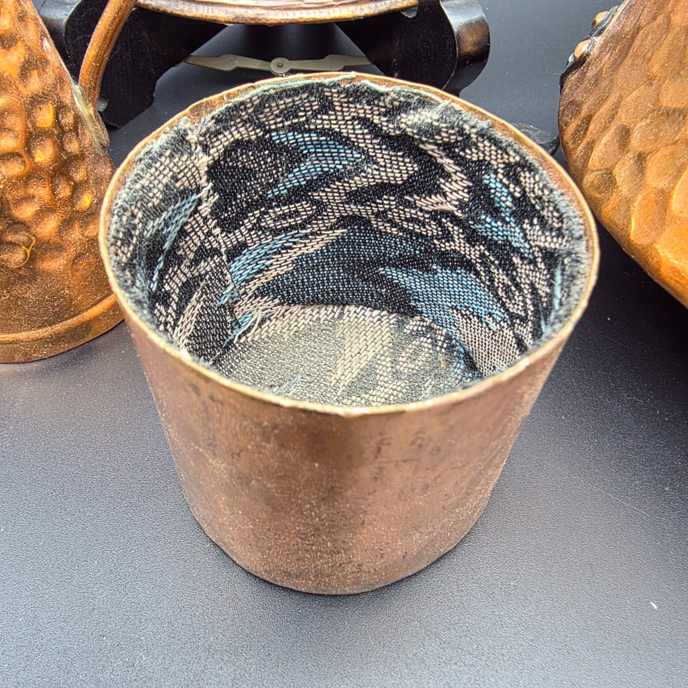 A collection of vintage copper and brass homewares, including an Aztec calendar wall hanging, pitchers, pots, and a Shakespeare-themed toasting fork. - View 6