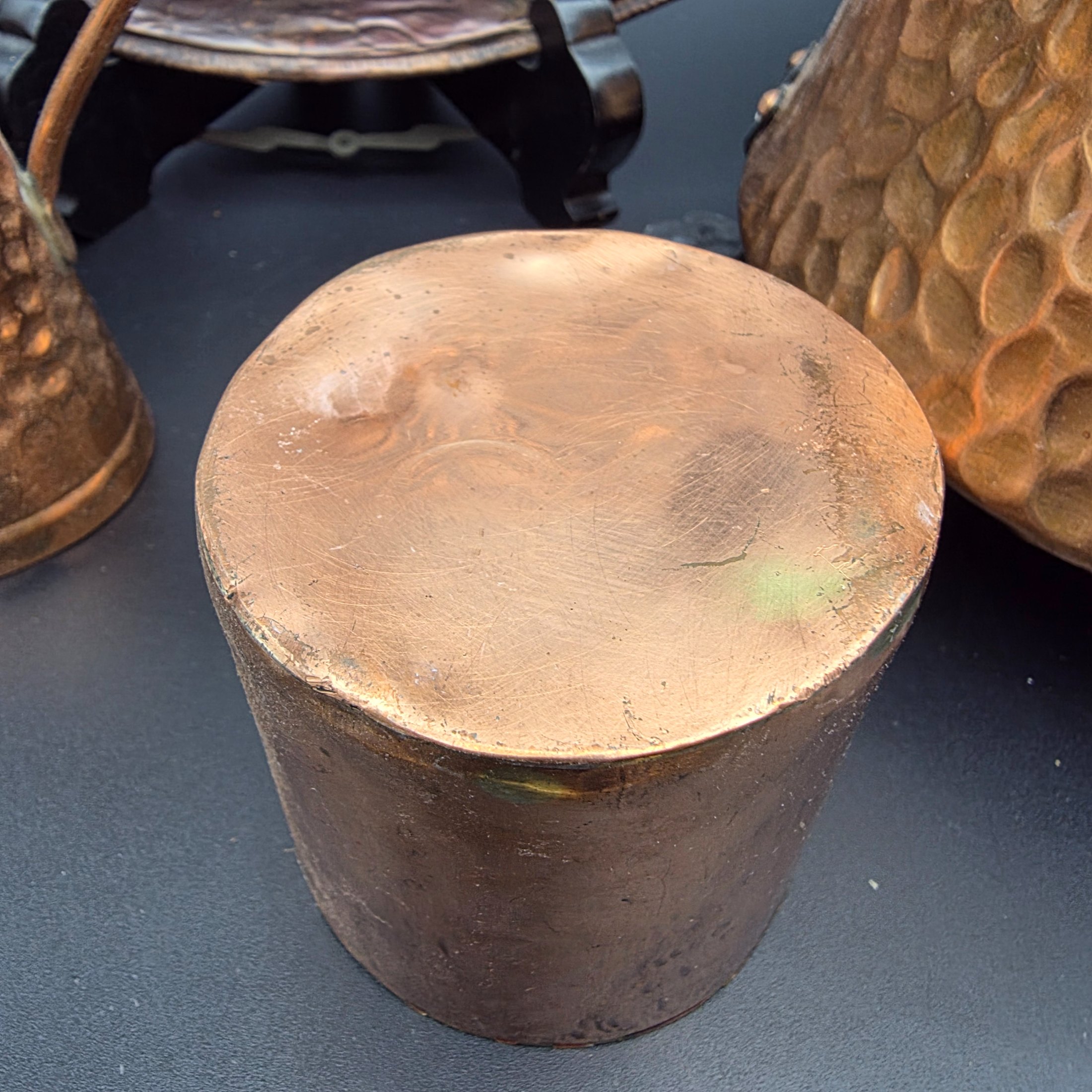 A collection of vintage copper and brass homewares, including an Aztec calendar wall hanging, pitchers, pots, and a Shakespeare-themed toasting fork. - View 7