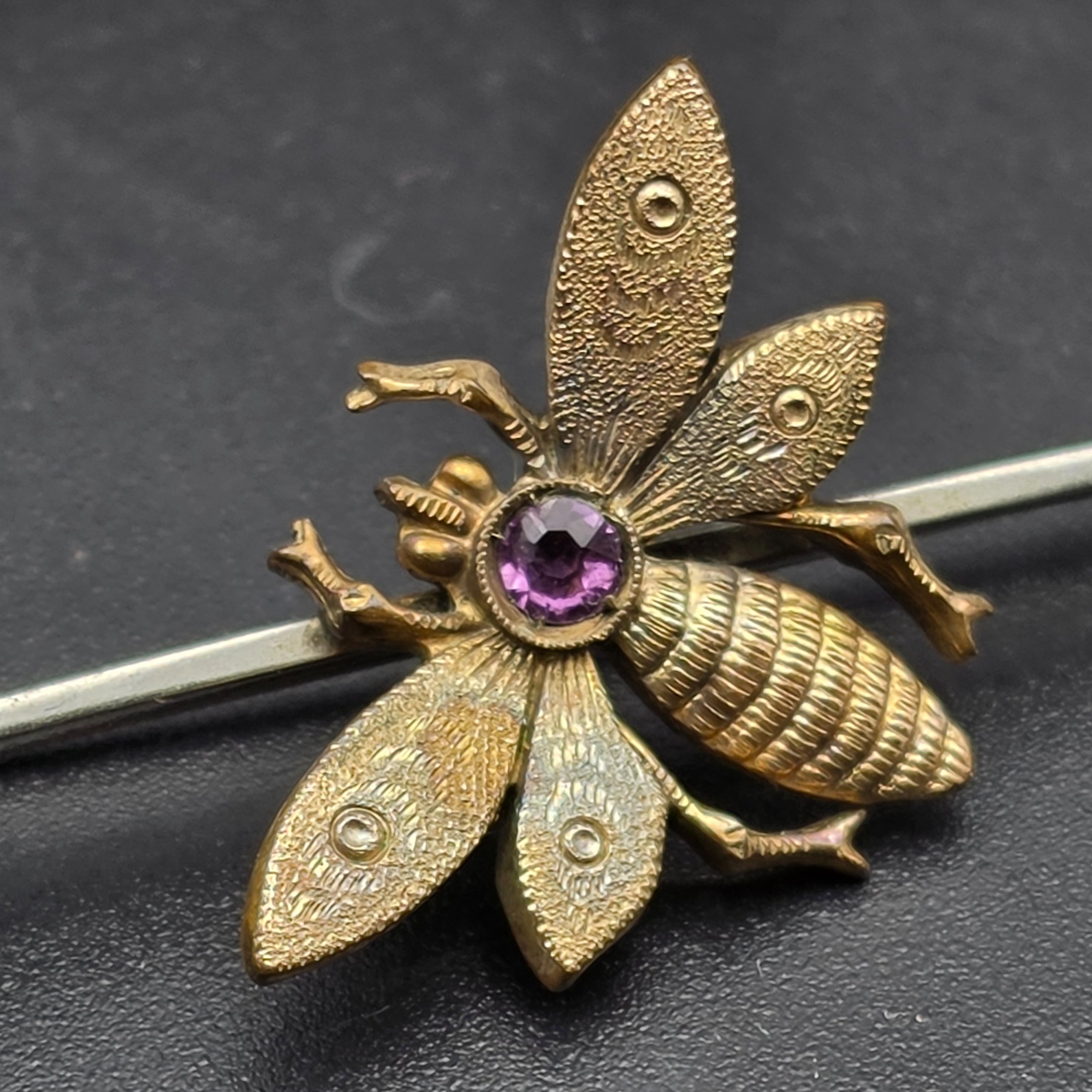 A collection of vintage personal accessories including a bee stick pin, a peacock brooch, a ceramic rose hat pin, and a cased magnifying glass in a red box. - View 2