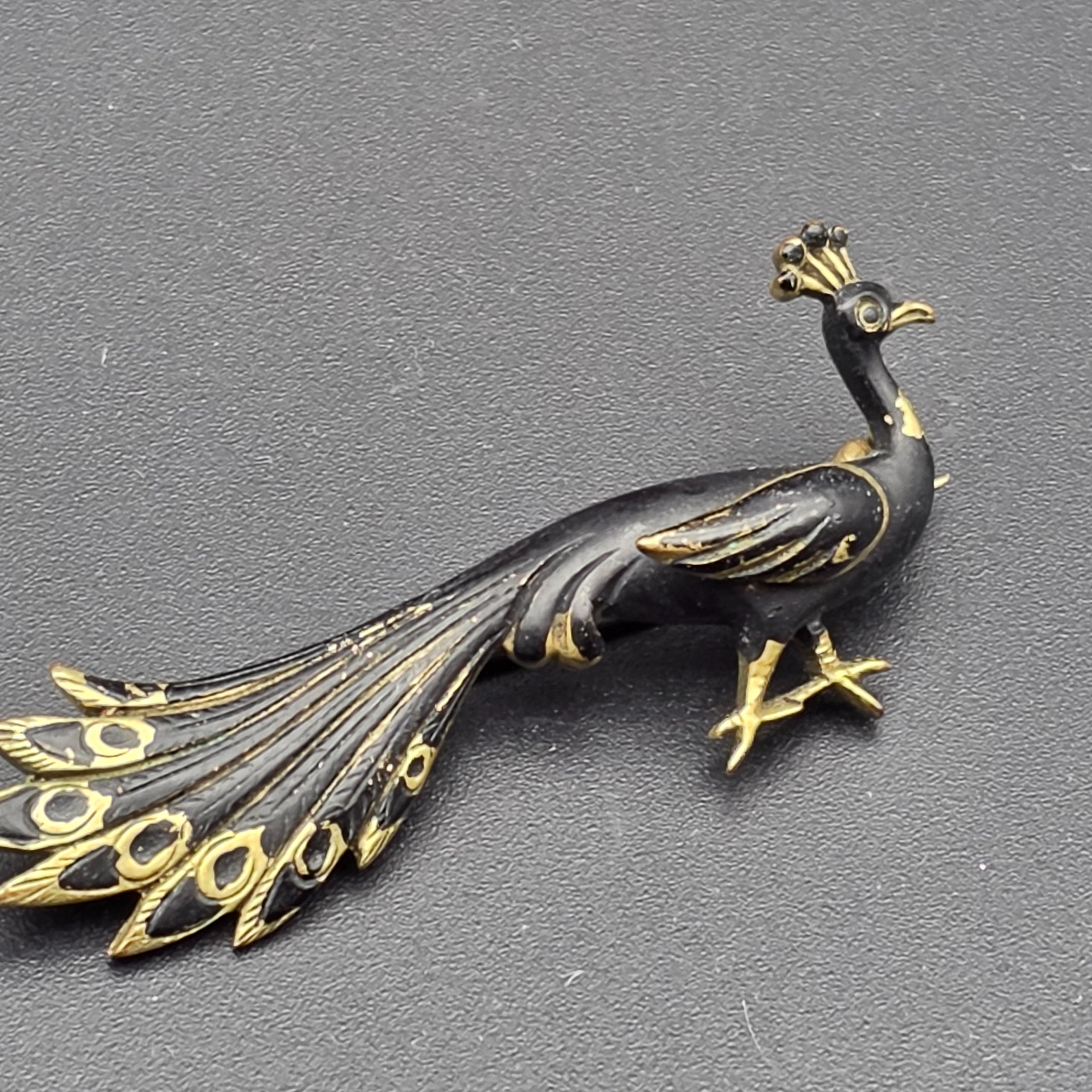 A collection of vintage personal accessories including a bee stick pin, a peacock brooch, a ceramic rose hat pin, and a cased magnifying glass in a red box. - View 4