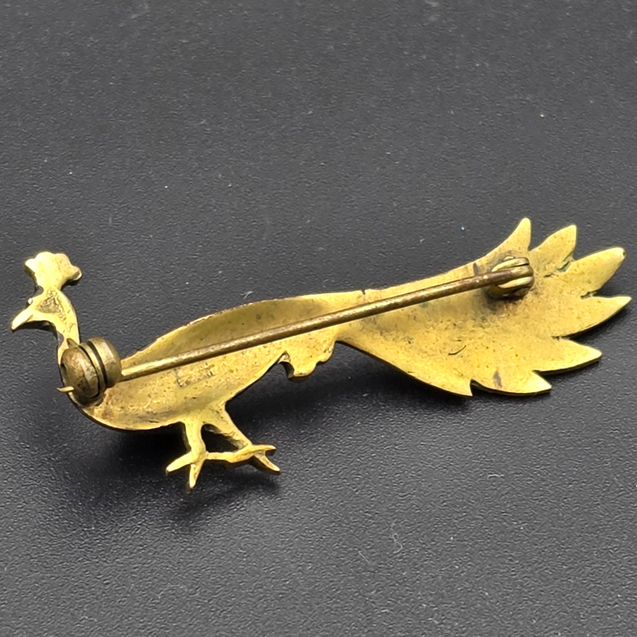 A collection of vintage personal accessories including a bee stick pin, a peacock brooch, a ceramic rose hat pin, and a cased magnifying glass in a red box. - View 5