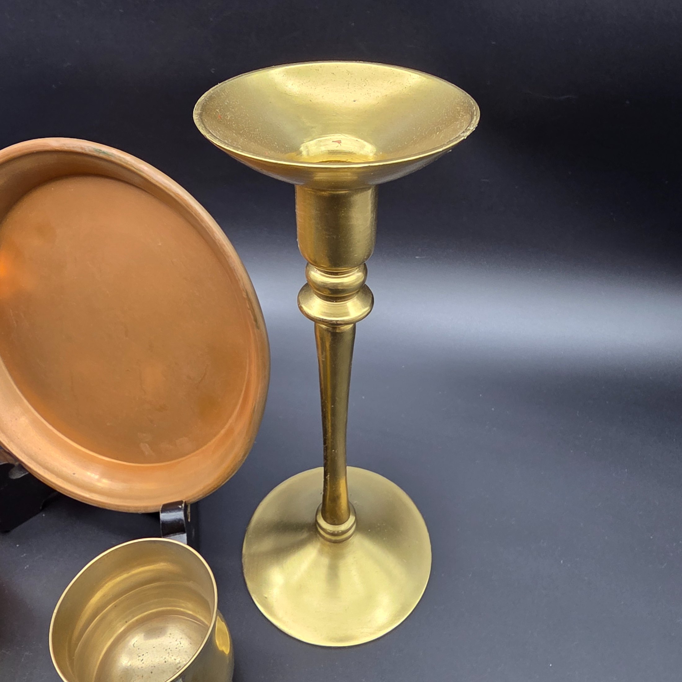 A collection of various vintage brass and copper sundries, including candlesticks, a decorative tray, a mug, an ashtray, and a small basket. - View 3
