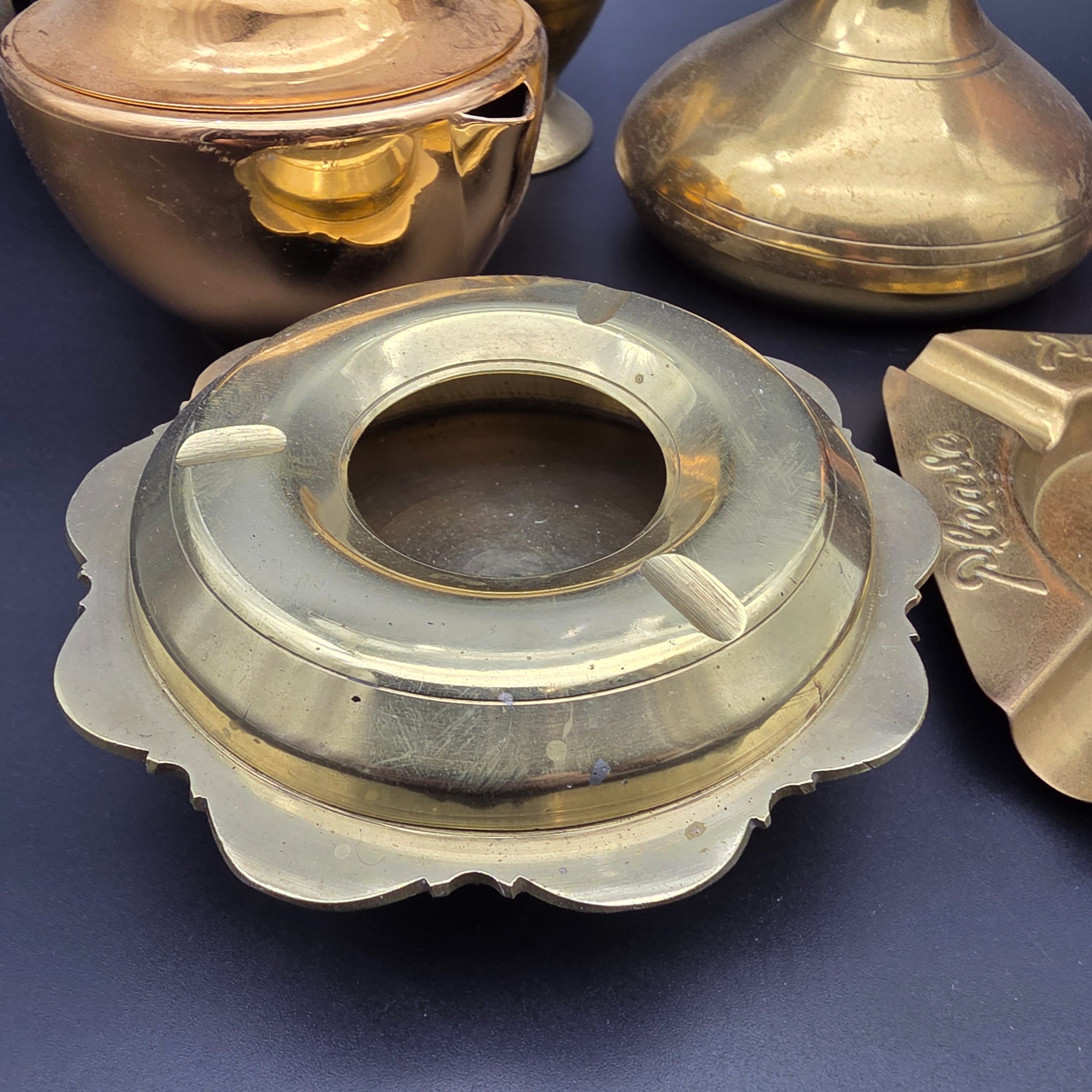 An appealing collection of eight assorted vintage brass and copper decorative items, including jugs, vases, pots, and ashtrays, showcasing varied forms and patinas from different eras and origins, ideal for display or use in period interiors. This lot includes an Australian-made Glama-Ware brass-finished stainless steel lidded pot and a 'Players' brand ashtray made in England. - View 3