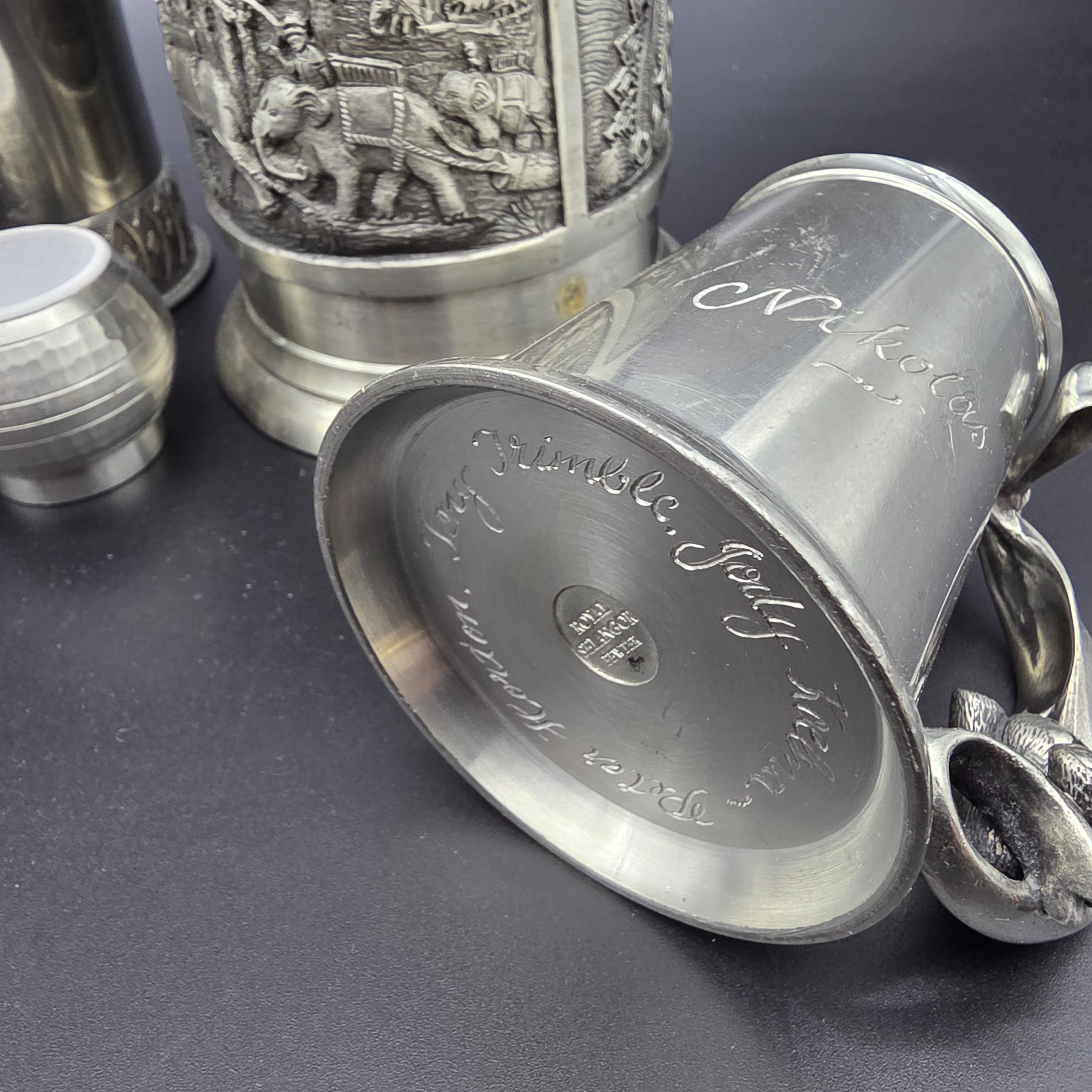 A collection of vintage pewter items including decorative mugs, cups, and small vases, displaying various finishes and makers' marks. - View 3