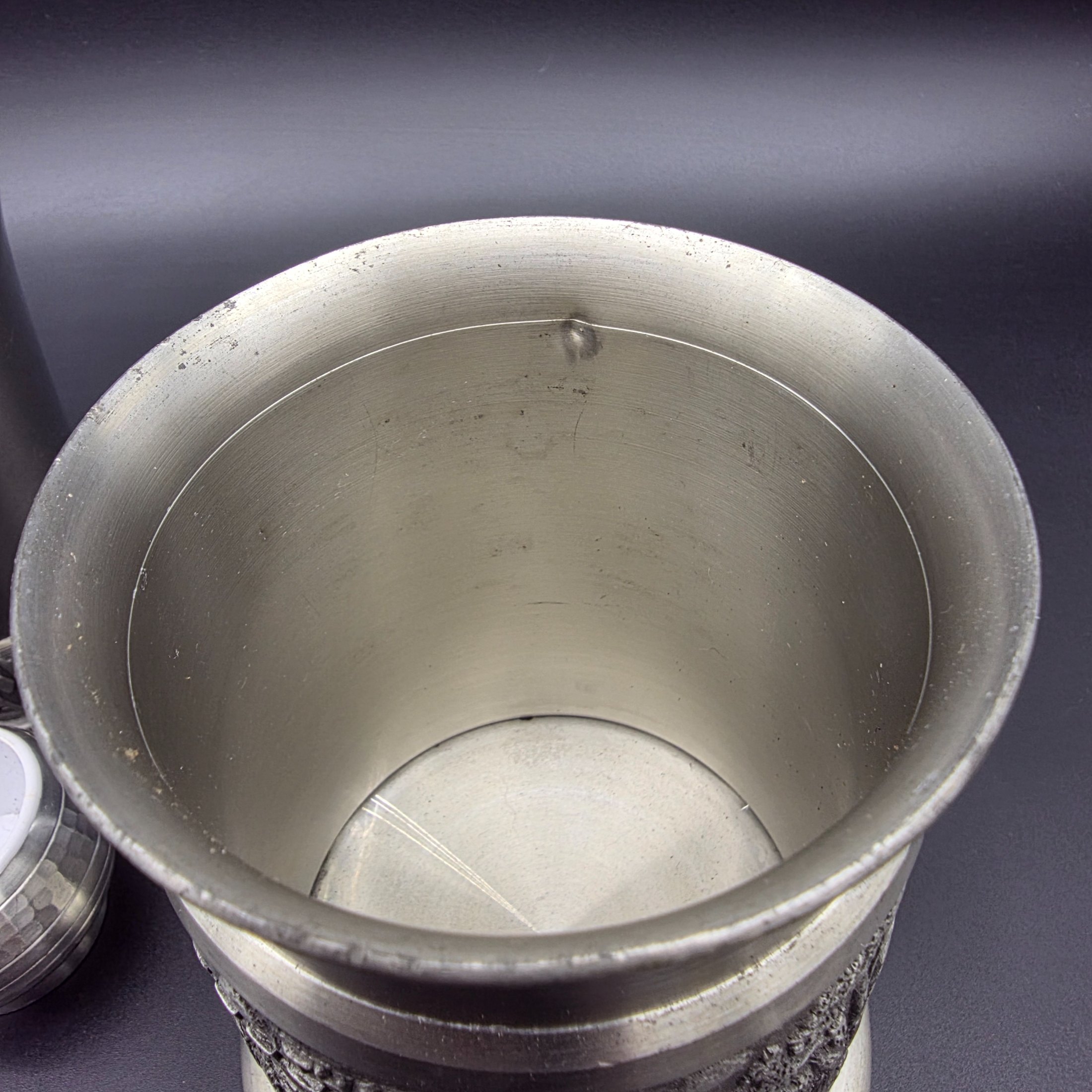 A collection of vintage pewter items including decorative mugs, cups, and small vases, displaying various finishes and makers' marks. - View 6