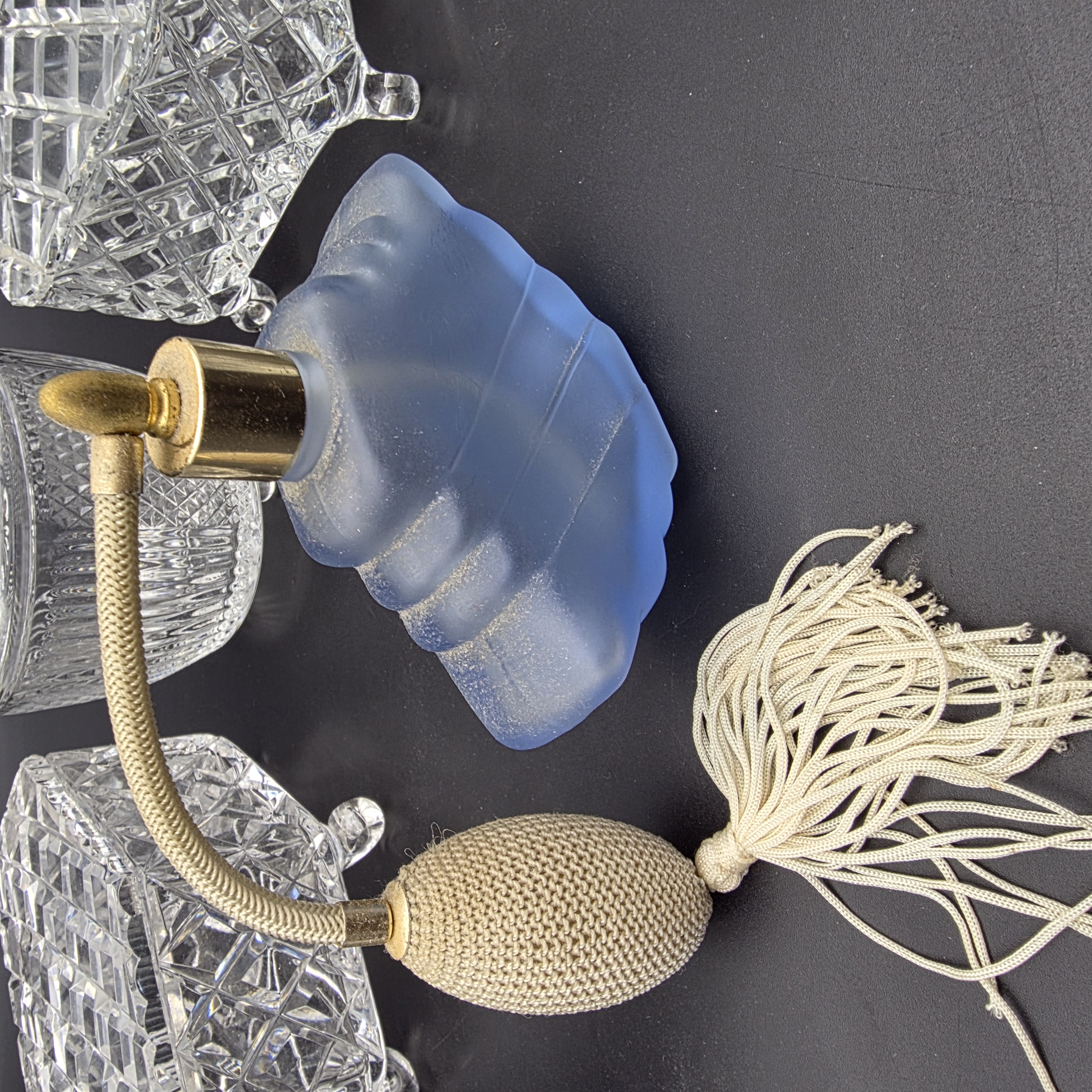 A charming collection of vintage cut glass and frosted vanity accessories, including lidded boxes, perfume bottles, and an atomizer, likely from the mid-20th century. - View 3