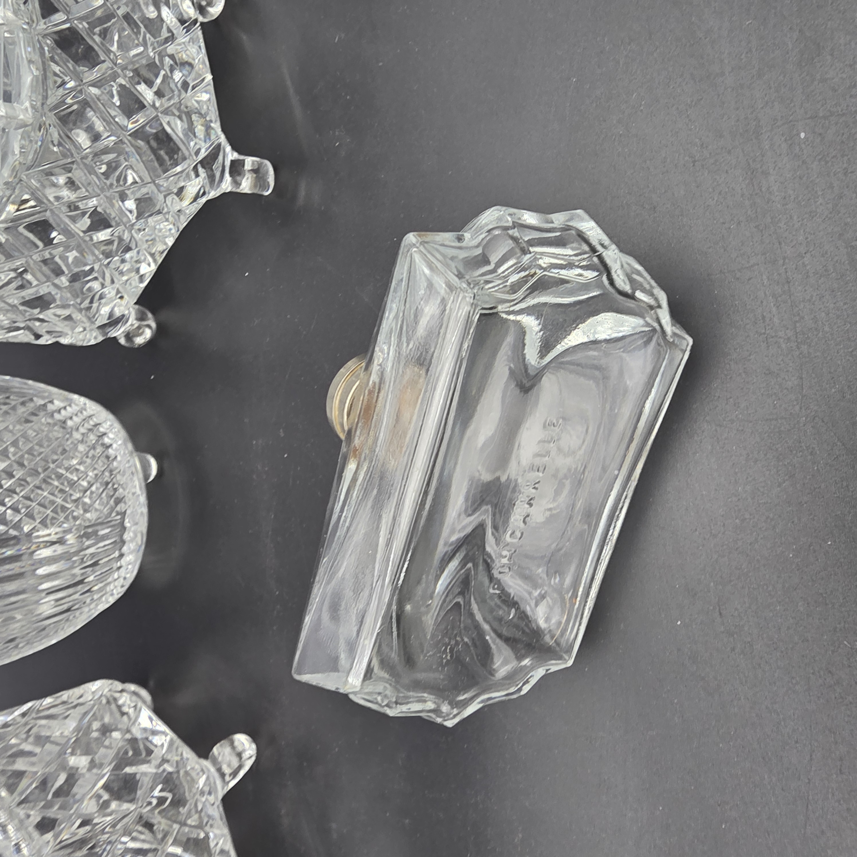 A charming collection of vintage cut glass and frosted vanity accessories, including lidded boxes, perfume bottles, and an atomizer, likely from the mid-20th century. - View 4