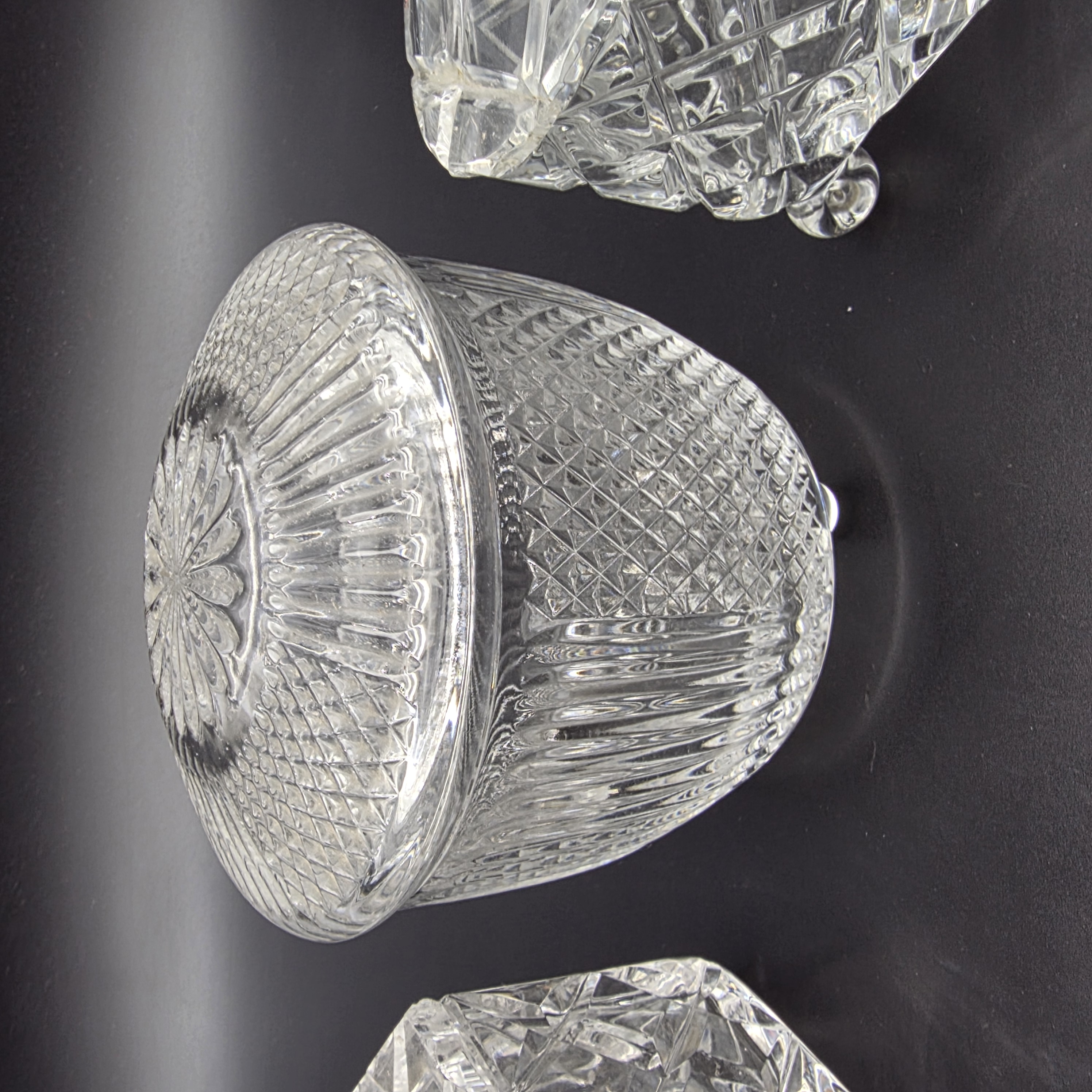 A charming collection of vintage cut glass and frosted vanity accessories, including lidded boxes, perfume bottles, and an atomizer, likely from the mid-20th century. - View 8