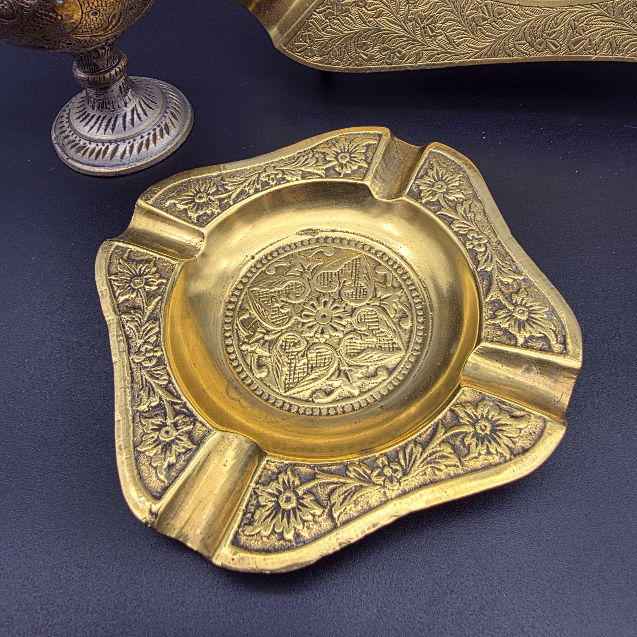 A collection of five vintage engraved brass and bronze decorative items, including three ashtrays, a vase, and a pear-shaped container. - View 5