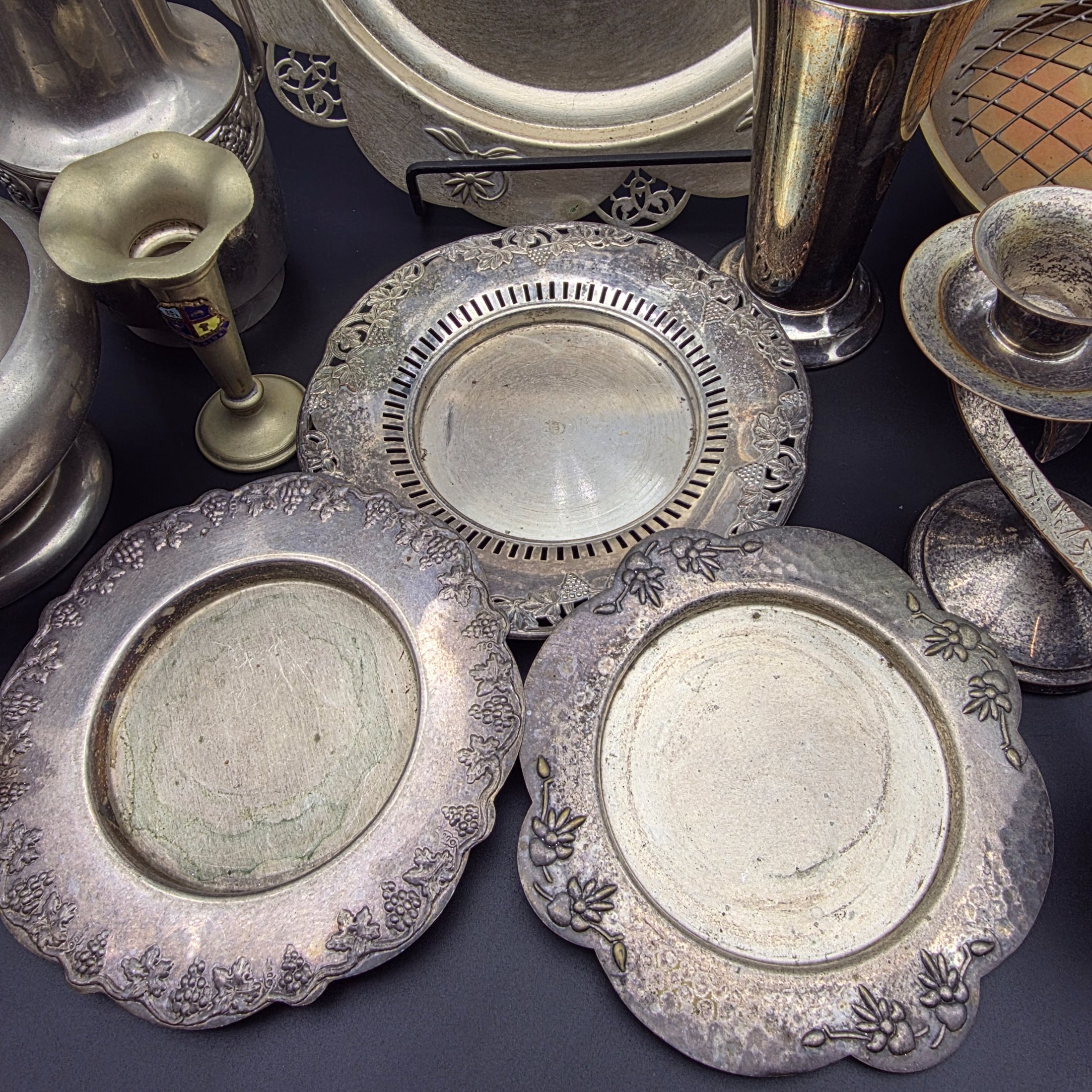 A varied collection of vintage homewares crafted from Britex Electroplated Britannia Metal (E.P.B.M.), 'Made in England', including trays, a pitcher, bowls, and a candelabra, all exhibiting significant tarnishing. - View 2