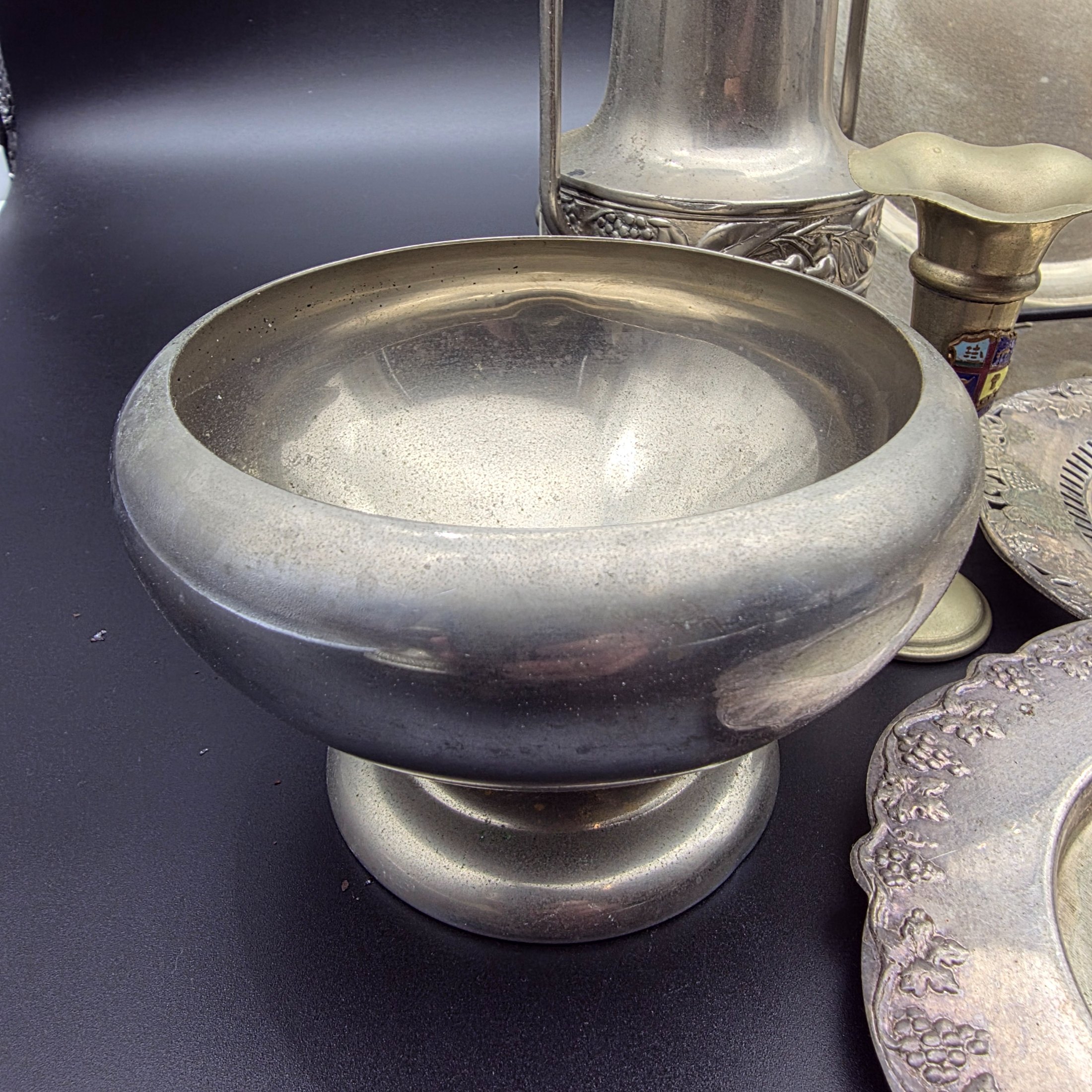A varied collection of vintage homewares crafted from Britex Electroplated Britannia Metal (E.P.B.M.), 'Made in England', including trays, a pitcher, bowls, and a candelabra, all exhibiting significant tarnishing. - View 3