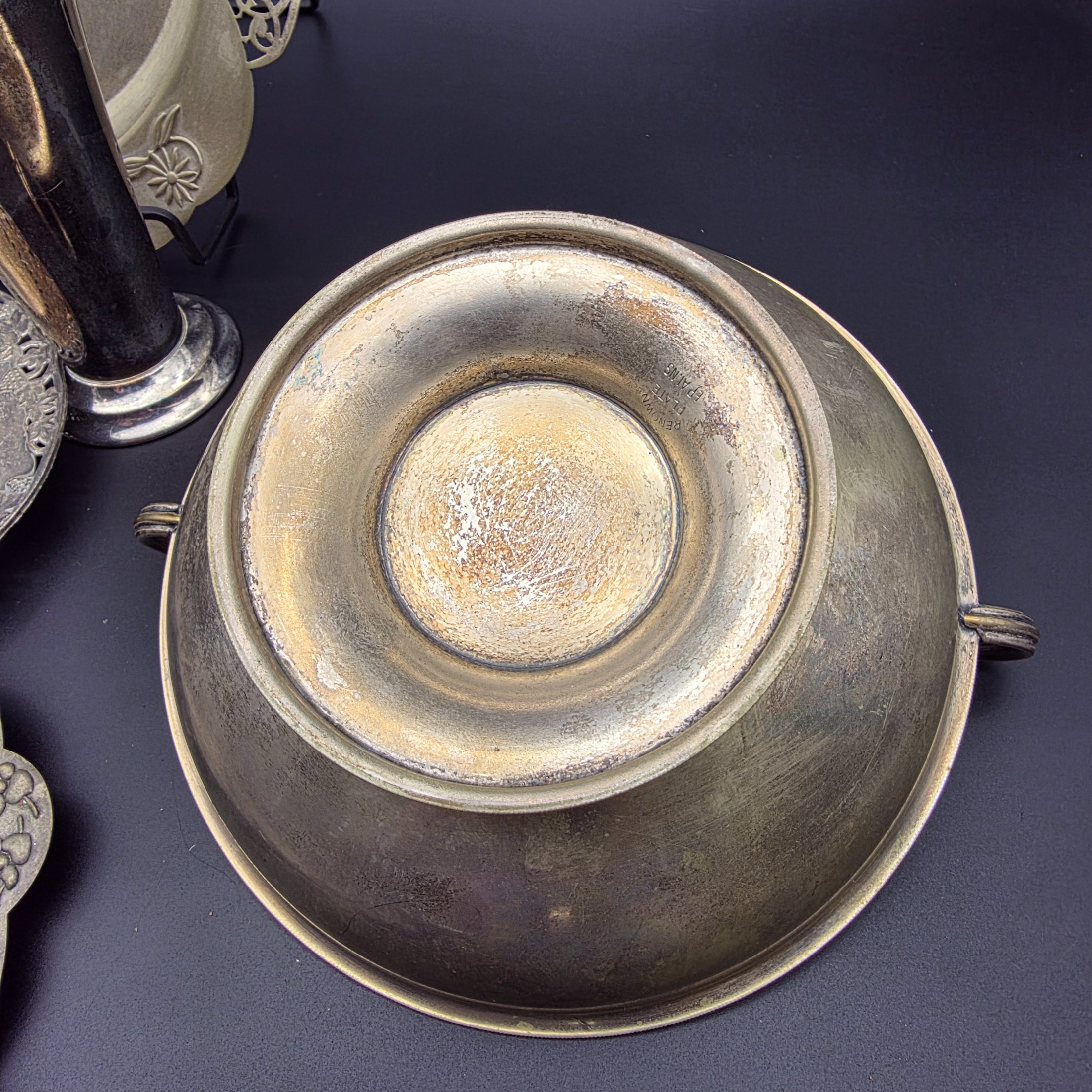A varied collection of vintage homewares crafted from Britex Electroplated Britannia Metal (E.P.B.M.), 'Made in England', including trays, a pitcher, bowls, and a candelabra, all exhibiting significant tarnishing. - View 8