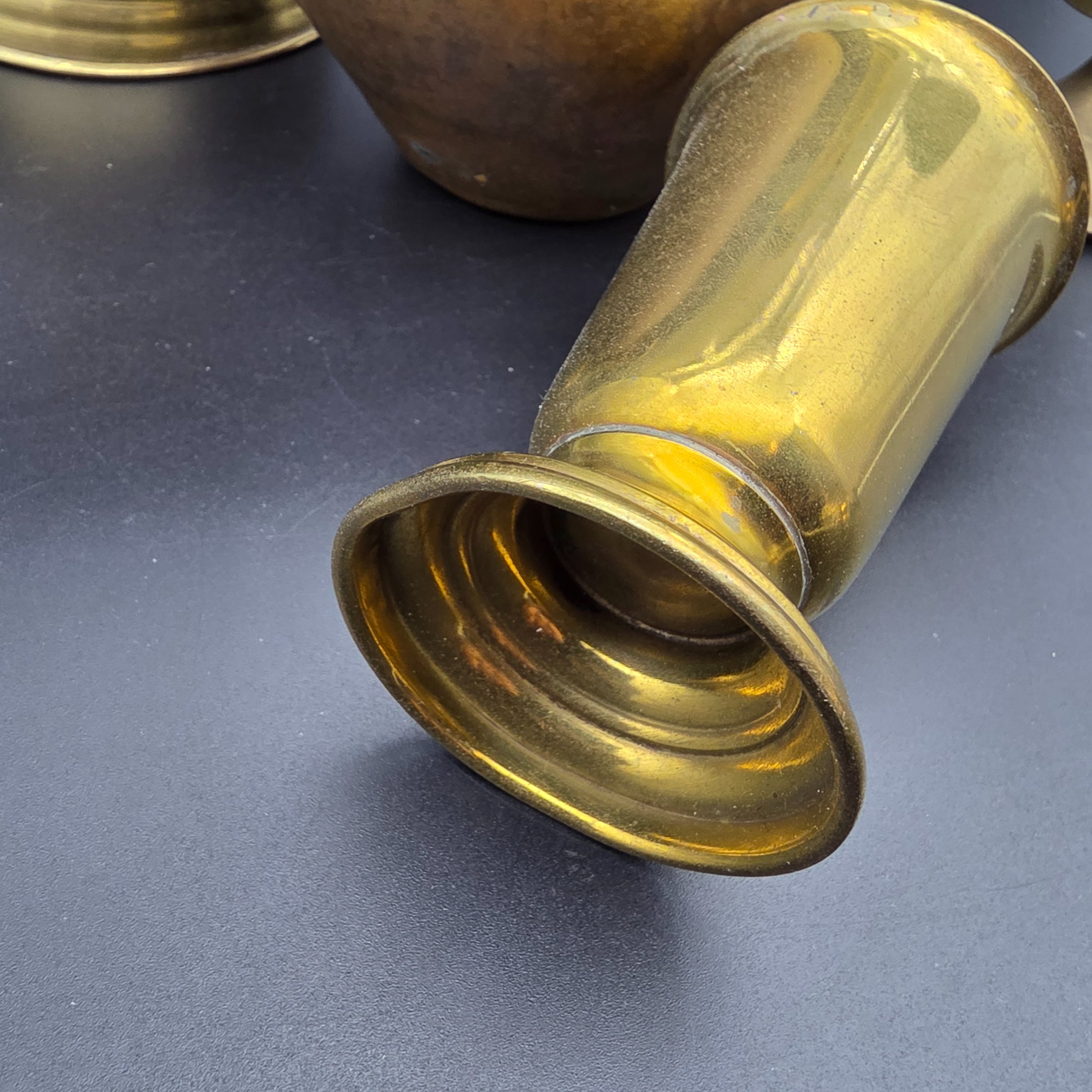A varied collection of five vintage decorative vessels crafted from brass and copper, including a small footed goblet, a rounded copper pot, a brass bucket with a handle, a tall handled brass urn, and a footed brass goblet with ornate banding. At least one piece bears a 'MADE IN INDIA' label, indicating a probable origin for the entire group. - View 5