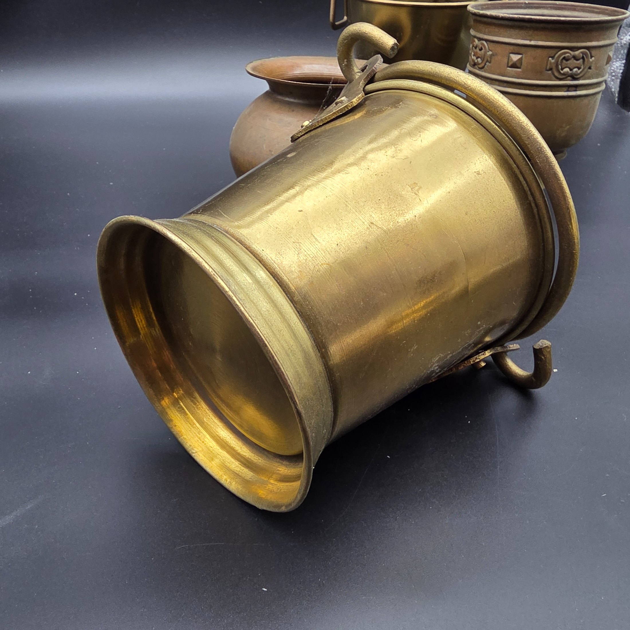 A varied collection of five vintage decorative vessels crafted from brass and copper, including a small footed goblet, a rounded copper pot, a brass bucket with a handle, a tall handled brass urn, and a footed brass goblet with ornate banding. At least one piece bears a 'MADE IN INDIA' label, indicating a probable origin for the entire group. - View 6