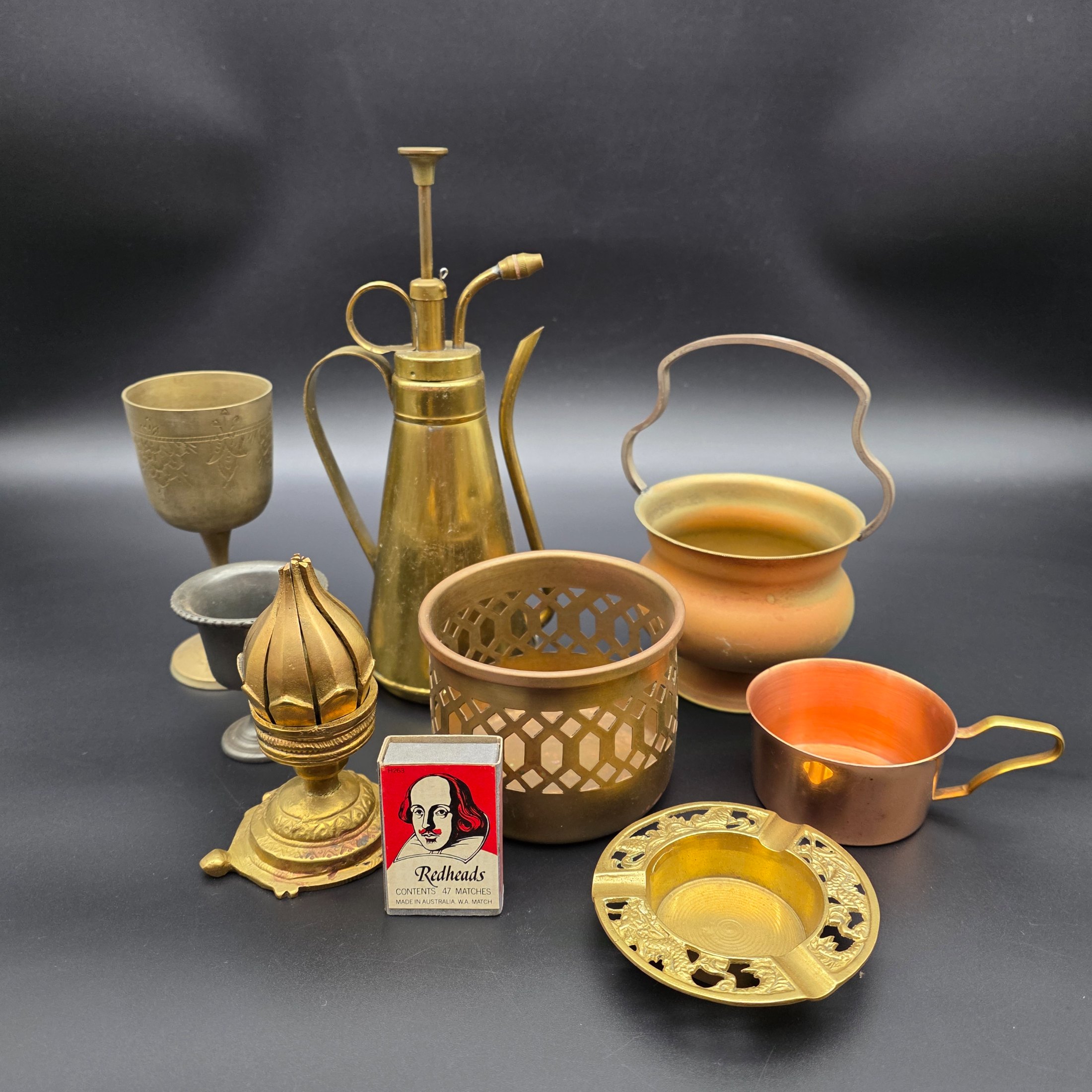 A varied collection of vintage brass and copper metalware, featuring decorative and functional items for home display.