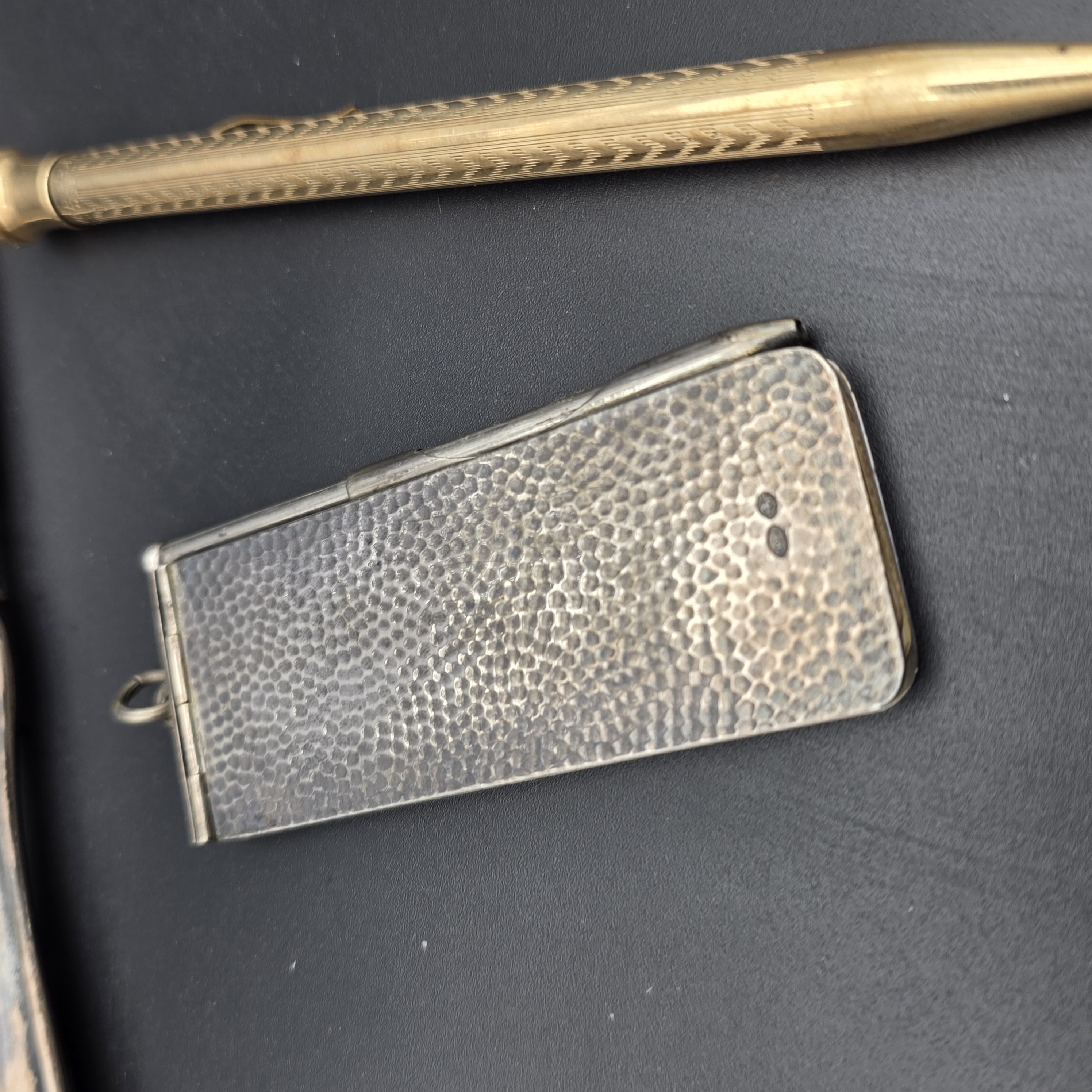 An intriguing collection of early 20th-century personal accessories, featuring sterling silver grooming tools and a notepad, alongside a classic gold-filled mechanical pencil. - View 2