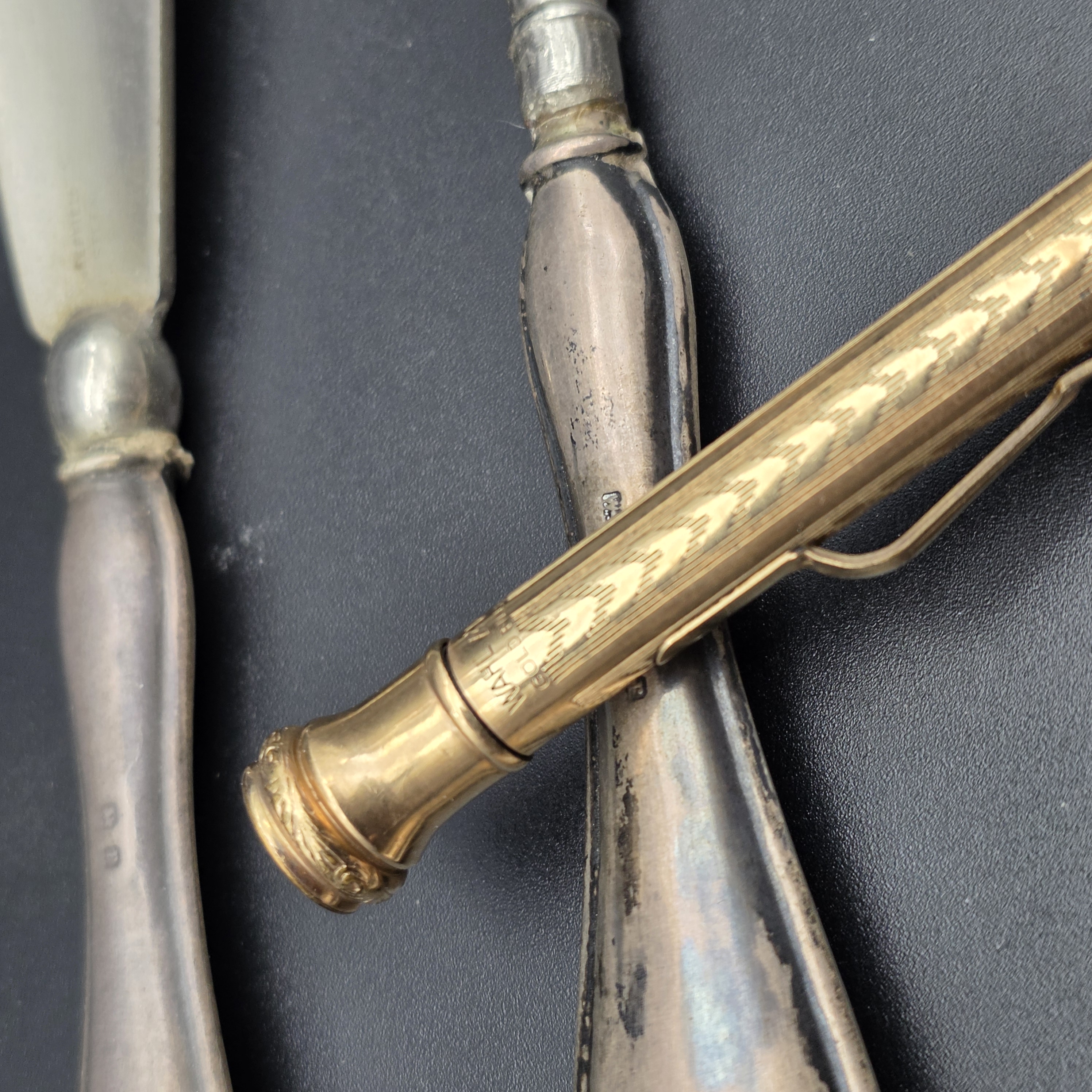 An intriguing collection of early 20th-century personal accessories, featuring sterling silver grooming tools and a notepad, alongside a classic gold-filled mechanical pencil. - View 5