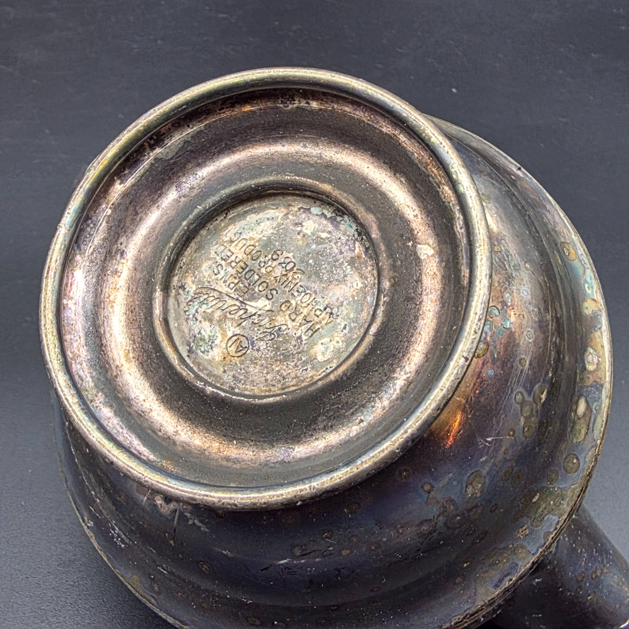 A varied collection of vintage silver-plated items including a butter dish, vase, creamer, bowls, and a toast rack, showing signs of heavy tarnishing and wear. - View 8