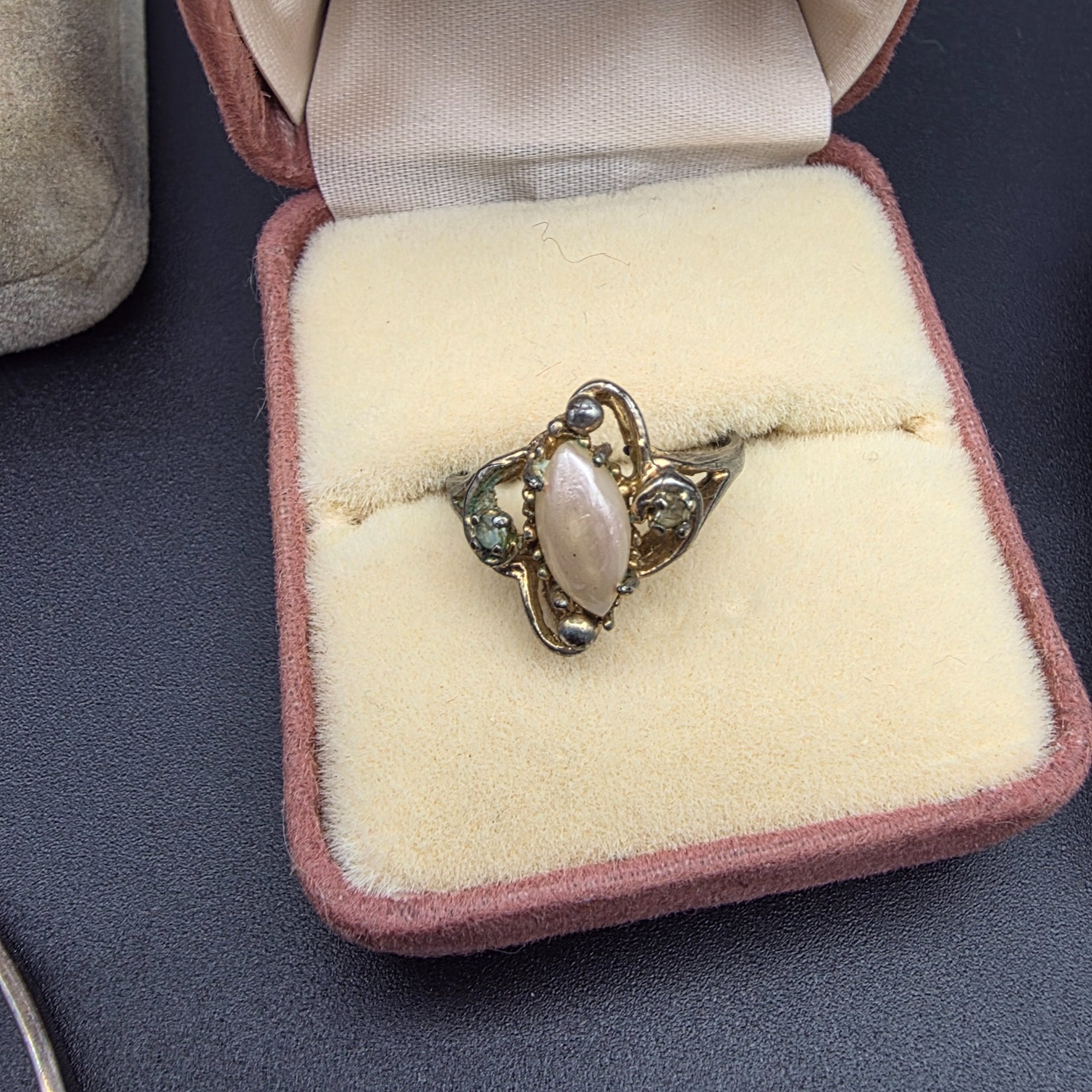 A diverse collection of vintage and sterling silver jewellery, including rings, brooches, necklaces, earrings, and a bangle, displayed across a dark surface. - View 5
