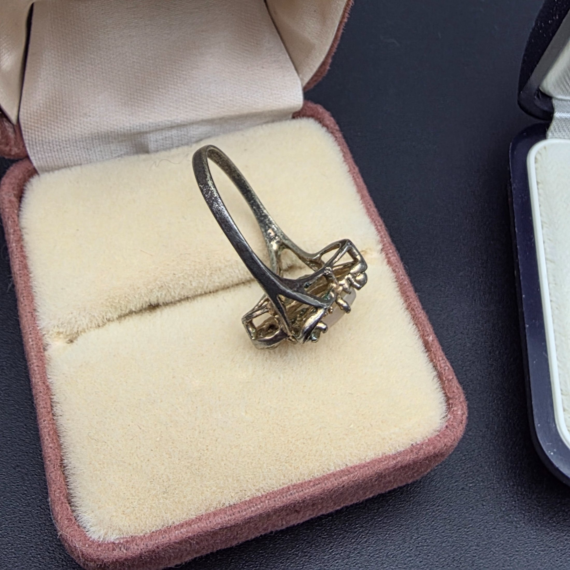 A diverse collection of vintage and sterling silver jewellery, including rings, brooches, necklaces, earrings, and a bangle, displayed across a dark surface. - View 8