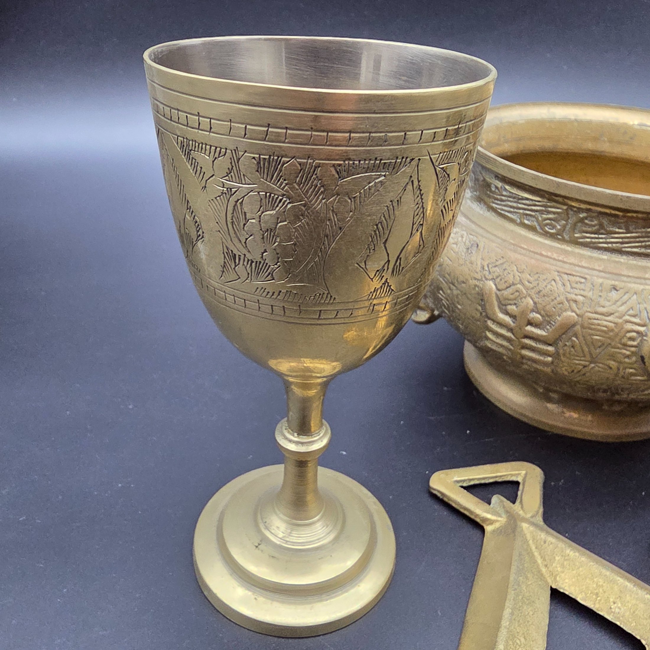 A collection of five assorted vintage brass ornamental pieces, including a goblet, vase, censer, and two smaller decorative items, all featuring intricate etchings and cast details. - View 3