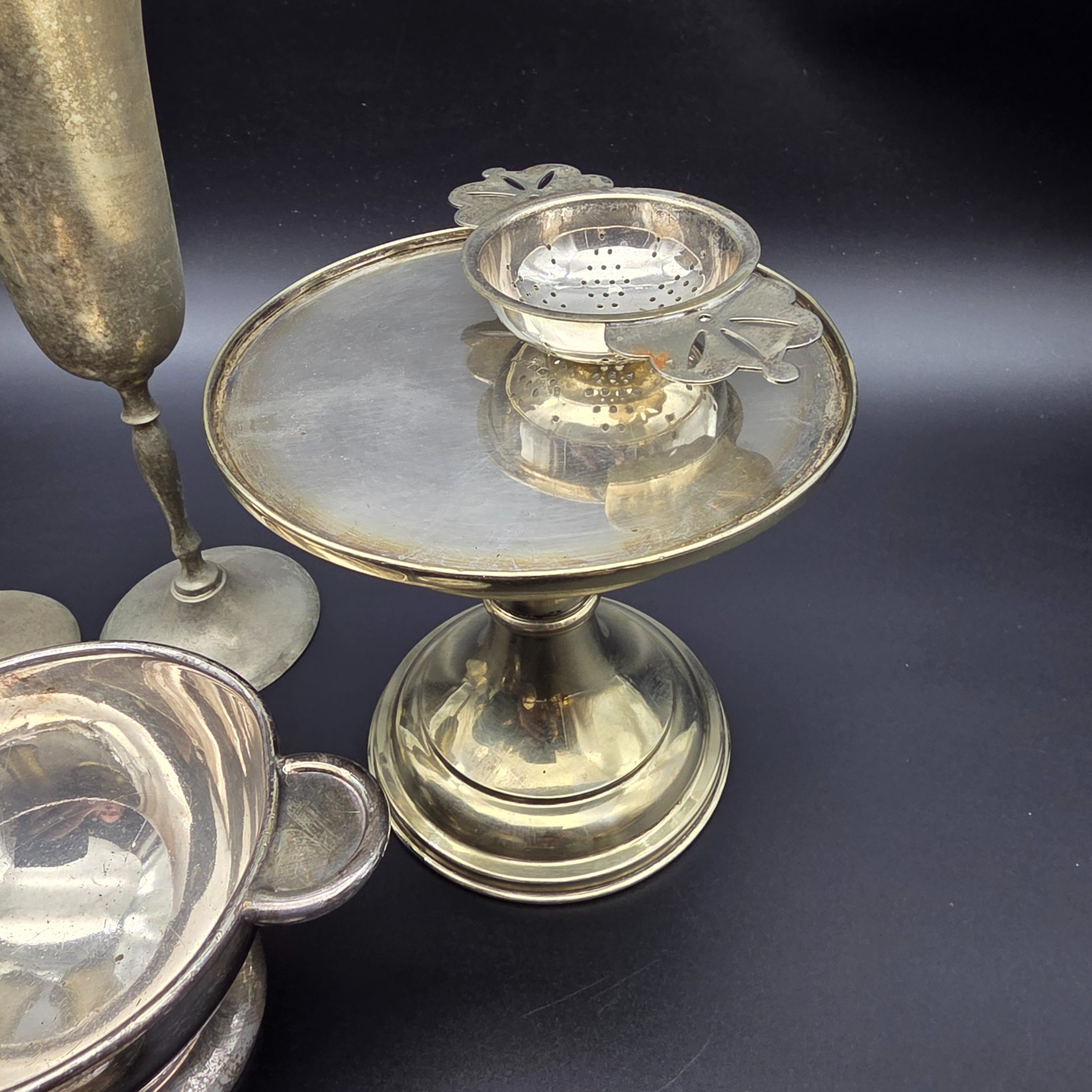 A diverse collection of antique and vintage metalware, primarily silver-plated and brass, featuring a variety of decorative and functional household items from the early to mid-20th century. - View 8