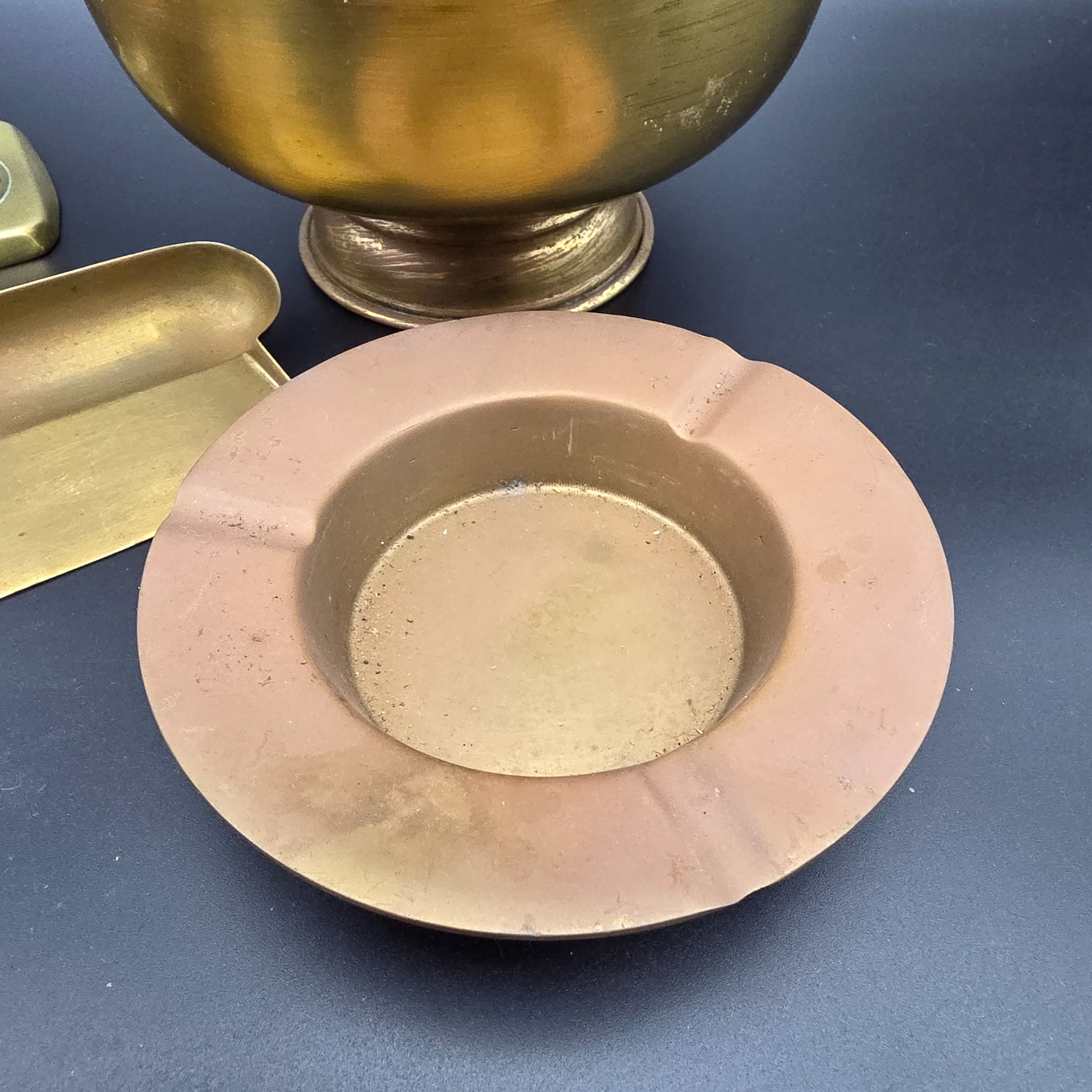 A collection of vintage metal home decor and utility items, featuring brass and copper pieces from the mid-20th century, including a planter, candlestick, crumb tray, copper dish, and ashtray. - View 2