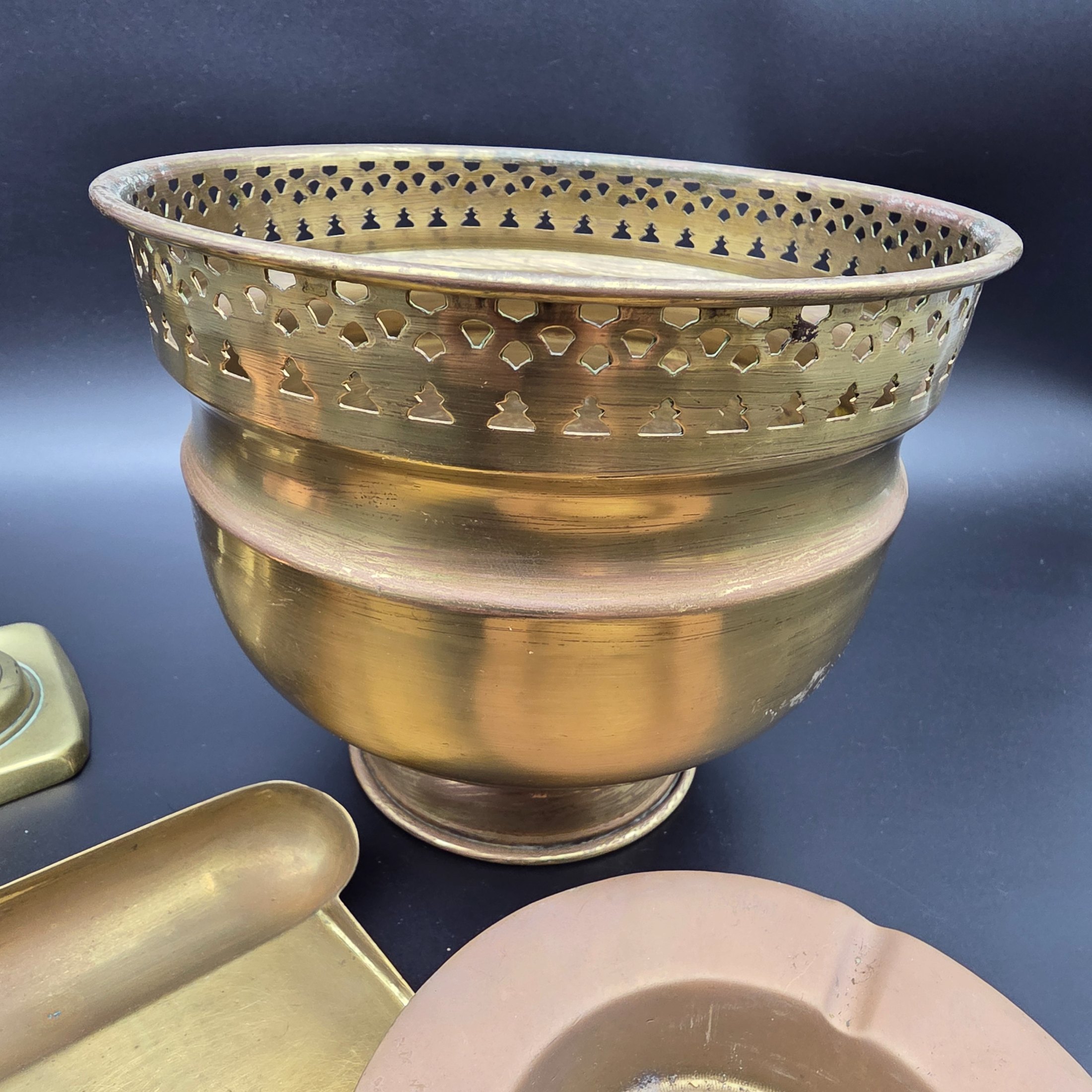A collection of vintage metal home decor and utility items, featuring brass and copper pieces from the mid-20th century, including a planter, candlestick, crumb tray, copper dish, and ashtray. - View 4
