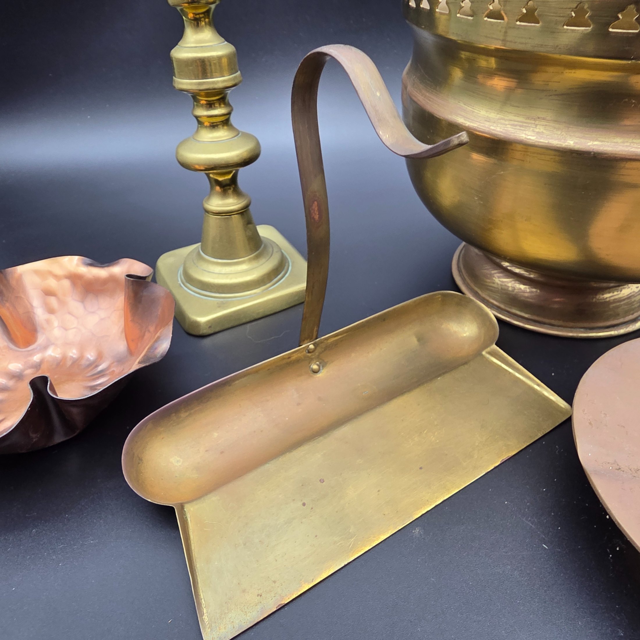 A collection of vintage metal home decor and utility items, featuring brass and copper pieces from the mid-20th century, including a planter, candlestick, crumb tray, copper dish, and ashtray. - View 5
