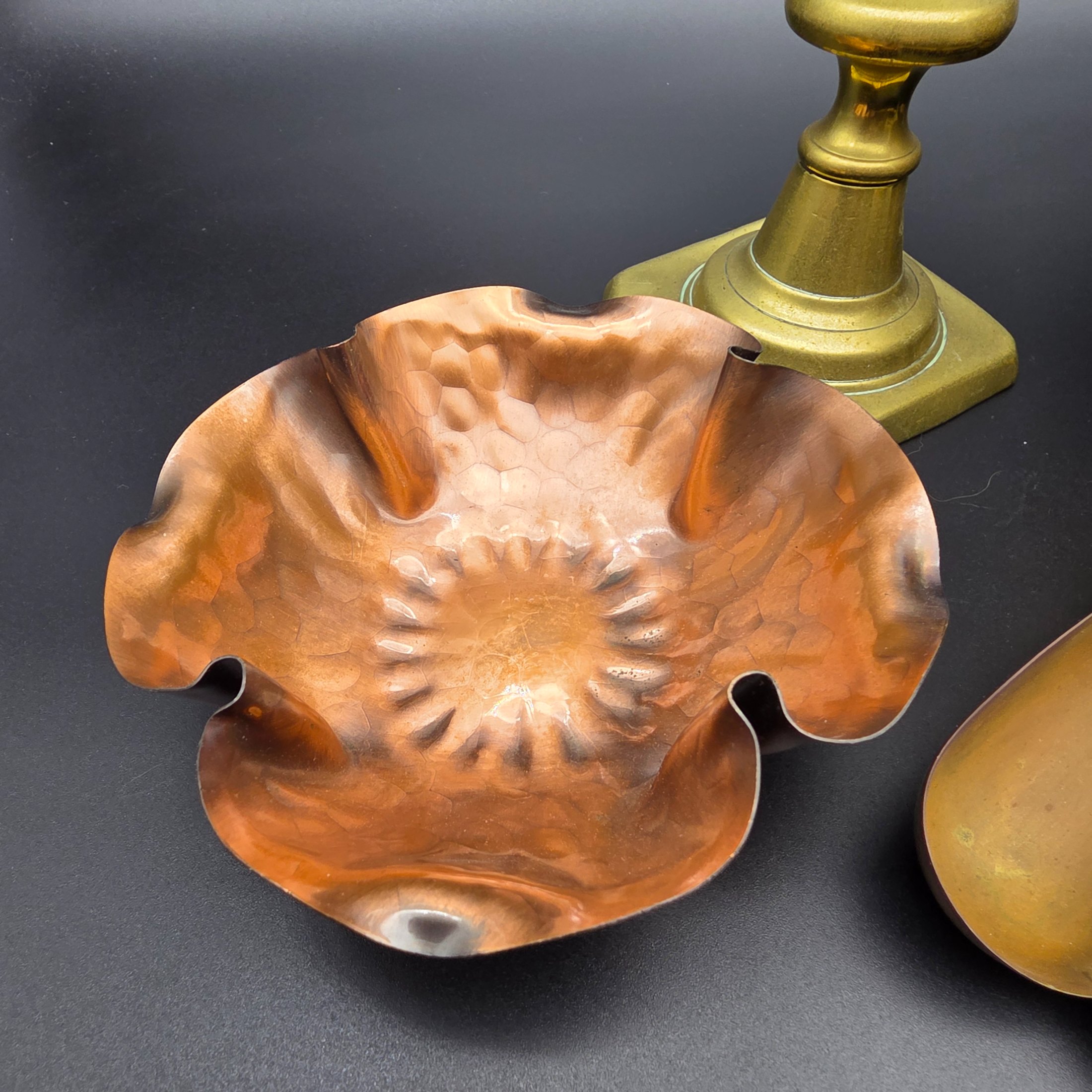 A collection of vintage metal home decor and utility items, featuring brass and copper pieces from the mid-20th century, including a planter, candlestick, crumb tray, copper dish, and ashtray. - View 7