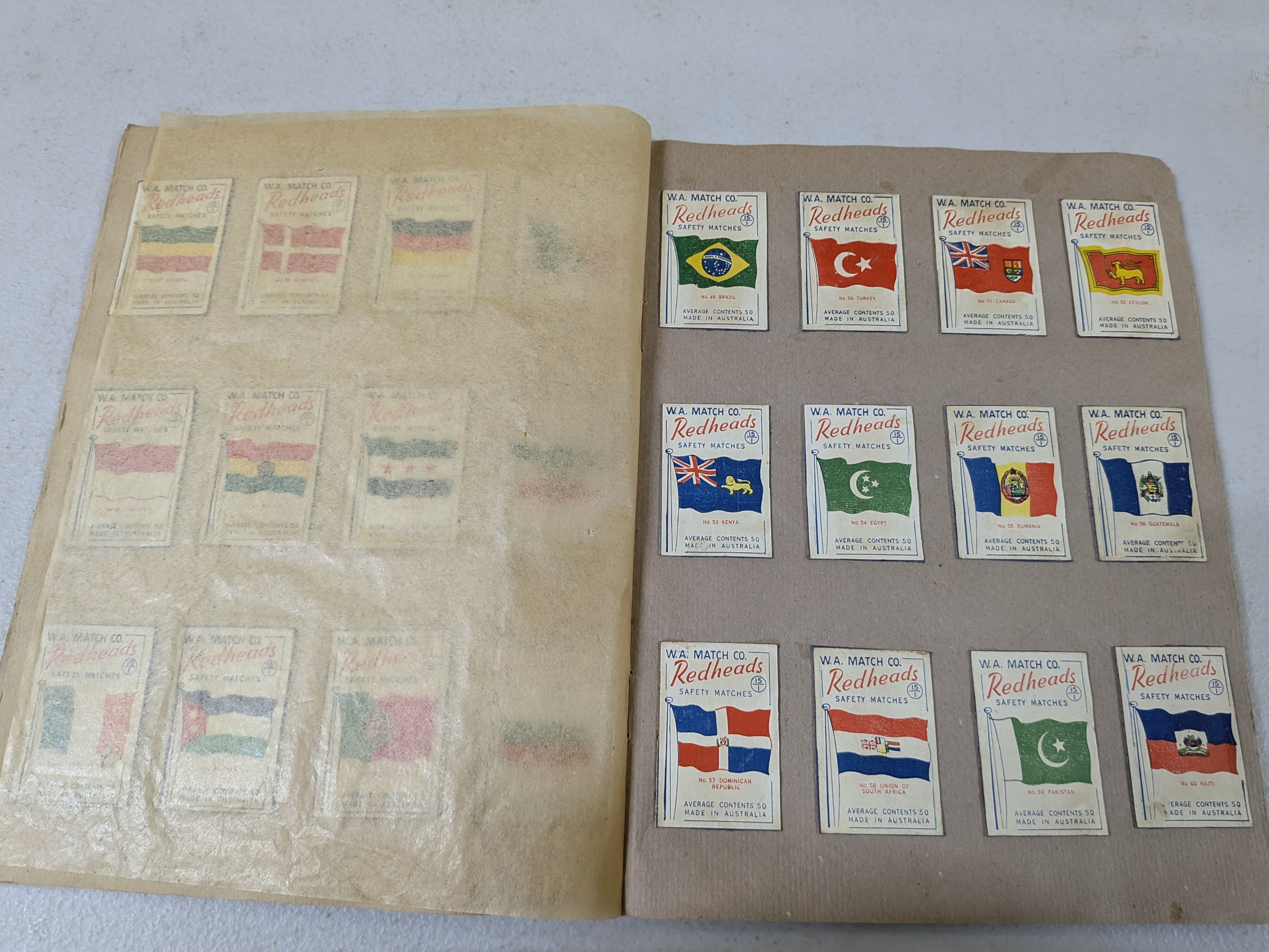 An album containing a collection of vintage Redheads Safety Matches labels, produced by W.A. Match Co. in Australia, showcasing various series including international flags and Australian fauna. - View 4