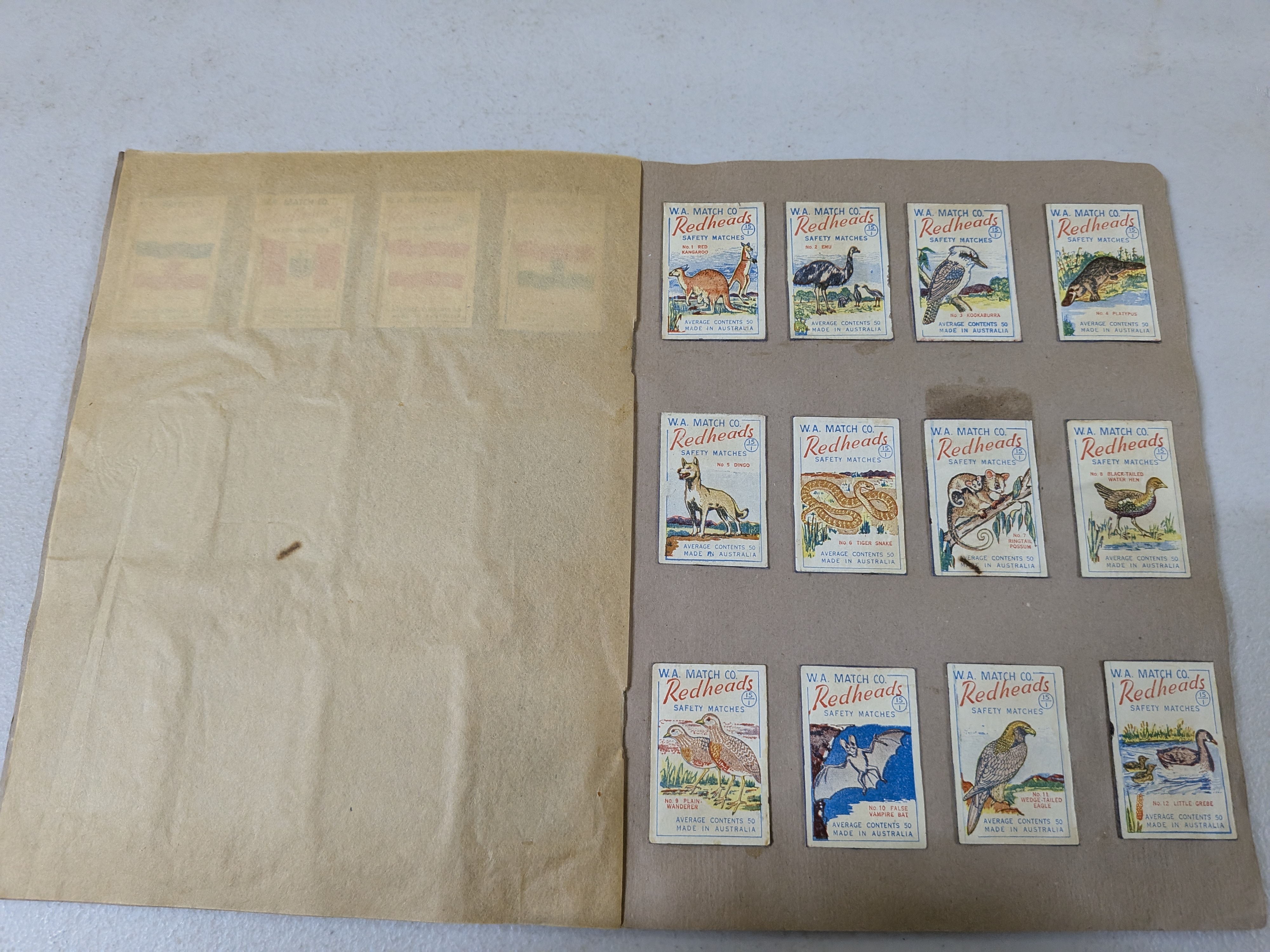 An album containing a collection of vintage Redheads Safety Matches labels, produced by W.A. Match Co. in Australia, showcasing various series including international flags and Australian fauna. - View 5
