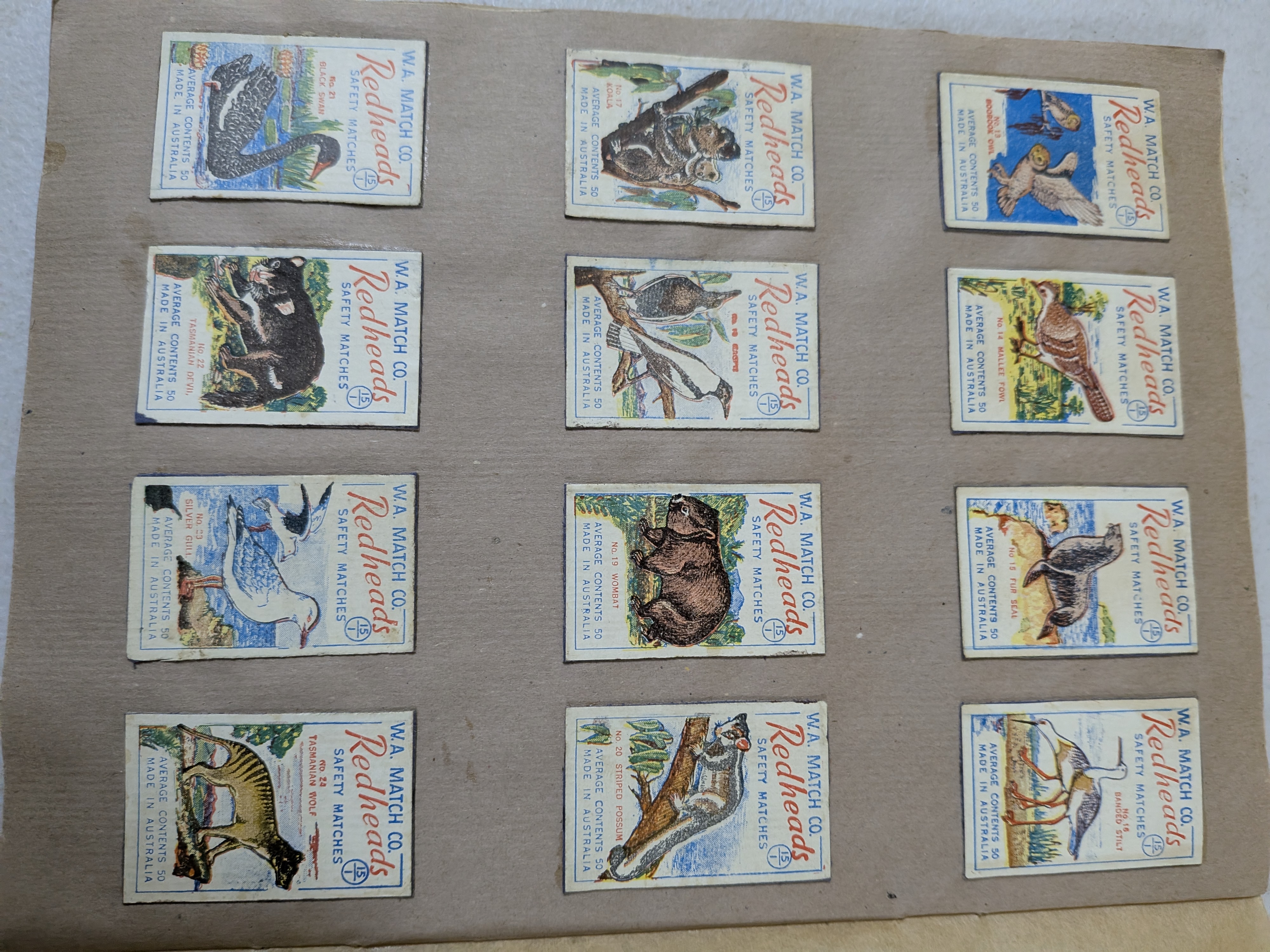 An album containing a collection of vintage Redheads Safety Matches labels, produced by W.A. Match Co. in Australia, showcasing various series including international flags and Australian fauna. - View 7