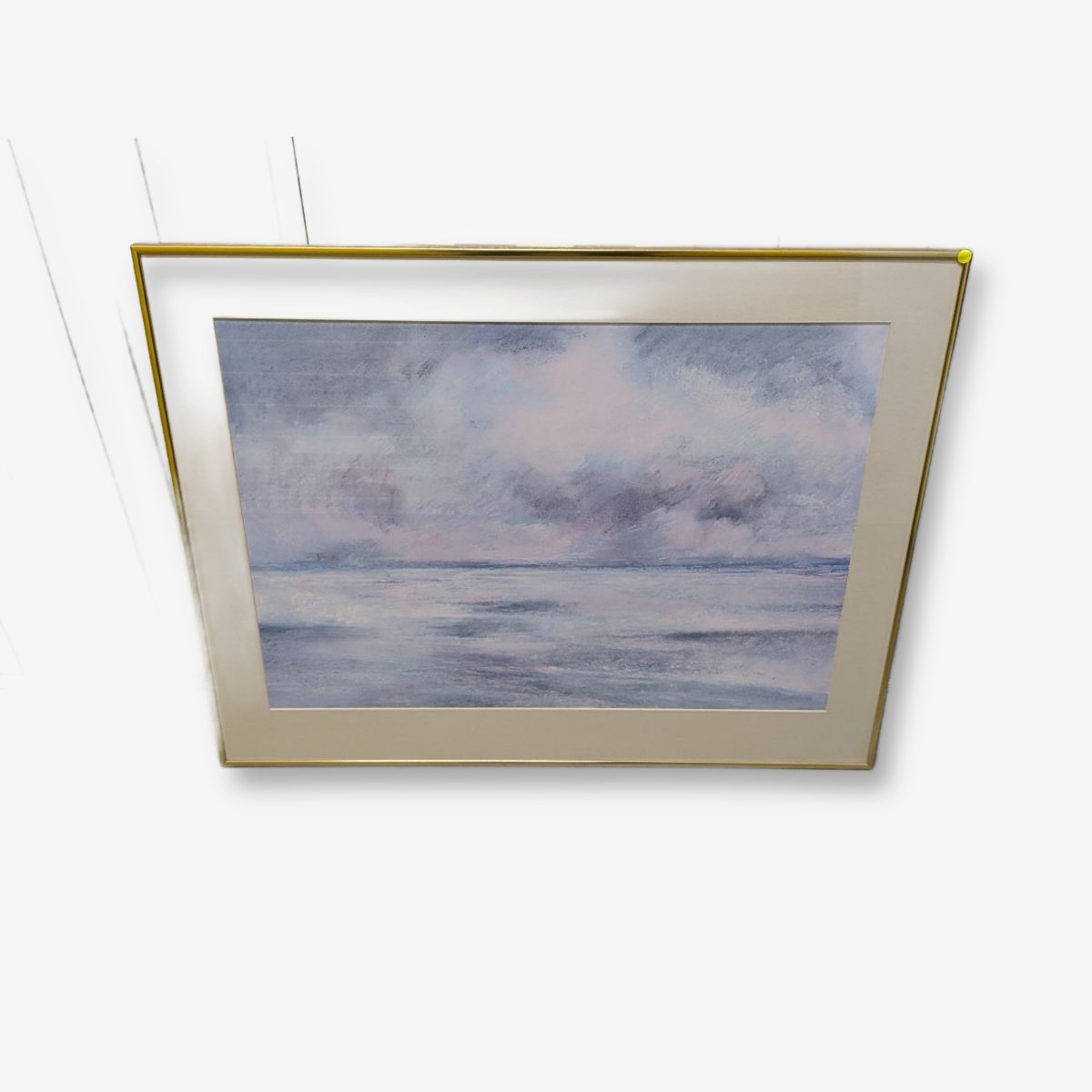 A framed impressionistic seascape painting depicting a serene ocean or lake under a cloudy sky, presented in a minimalist gold-tone frame, dated 1982. - View 2