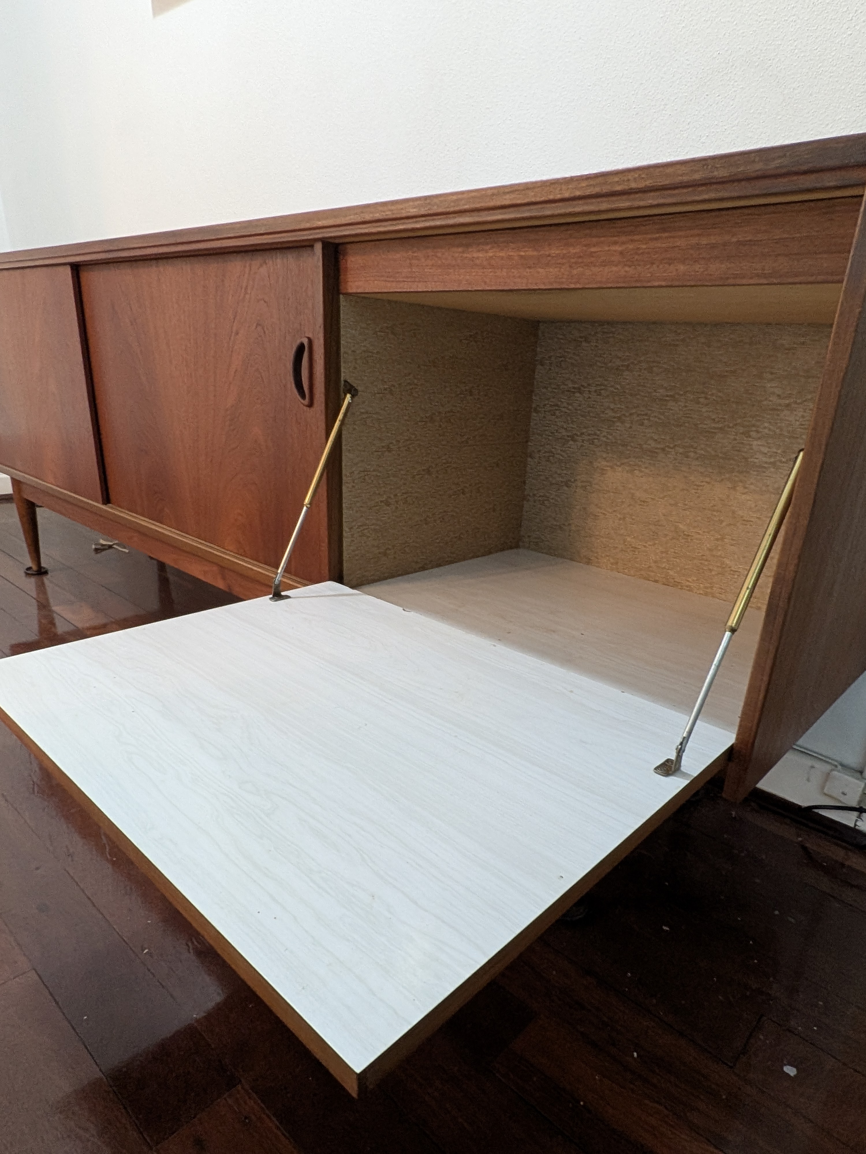 A classic Mid-Century Modern credenza, crafted from rich teak veneer with a warm, inviting tone, circa 1960s. This elegant piece features clean lines and functional design. - View 2