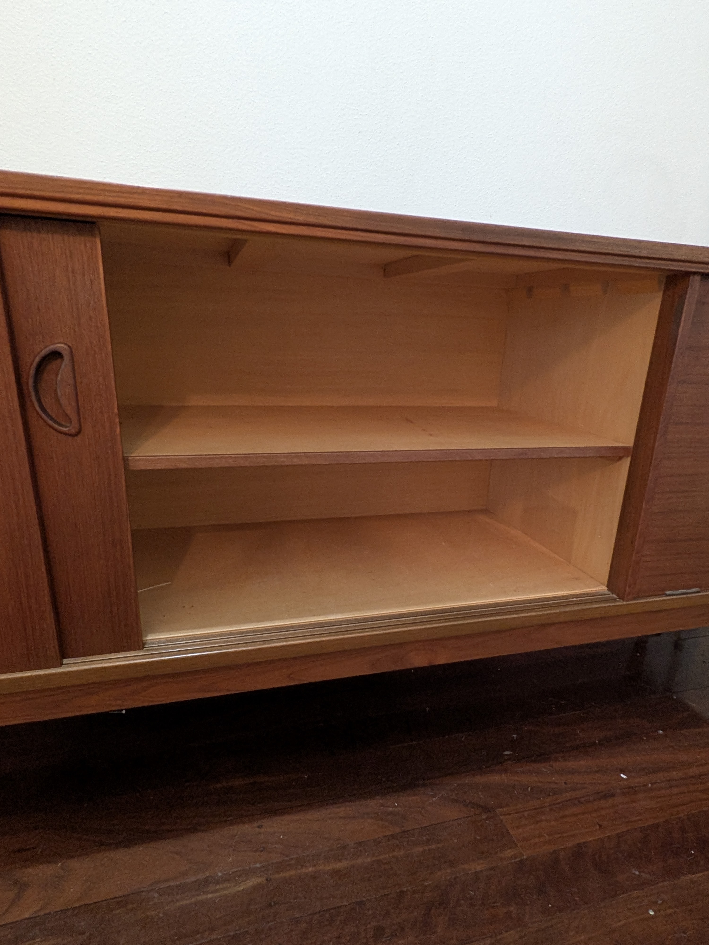 A classic Mid-Century Modern credenza, crafted from rich teak veneer with a warm, inviting tone, circa 1960s. This elegant piece features clean lines and functional design. - View 3
