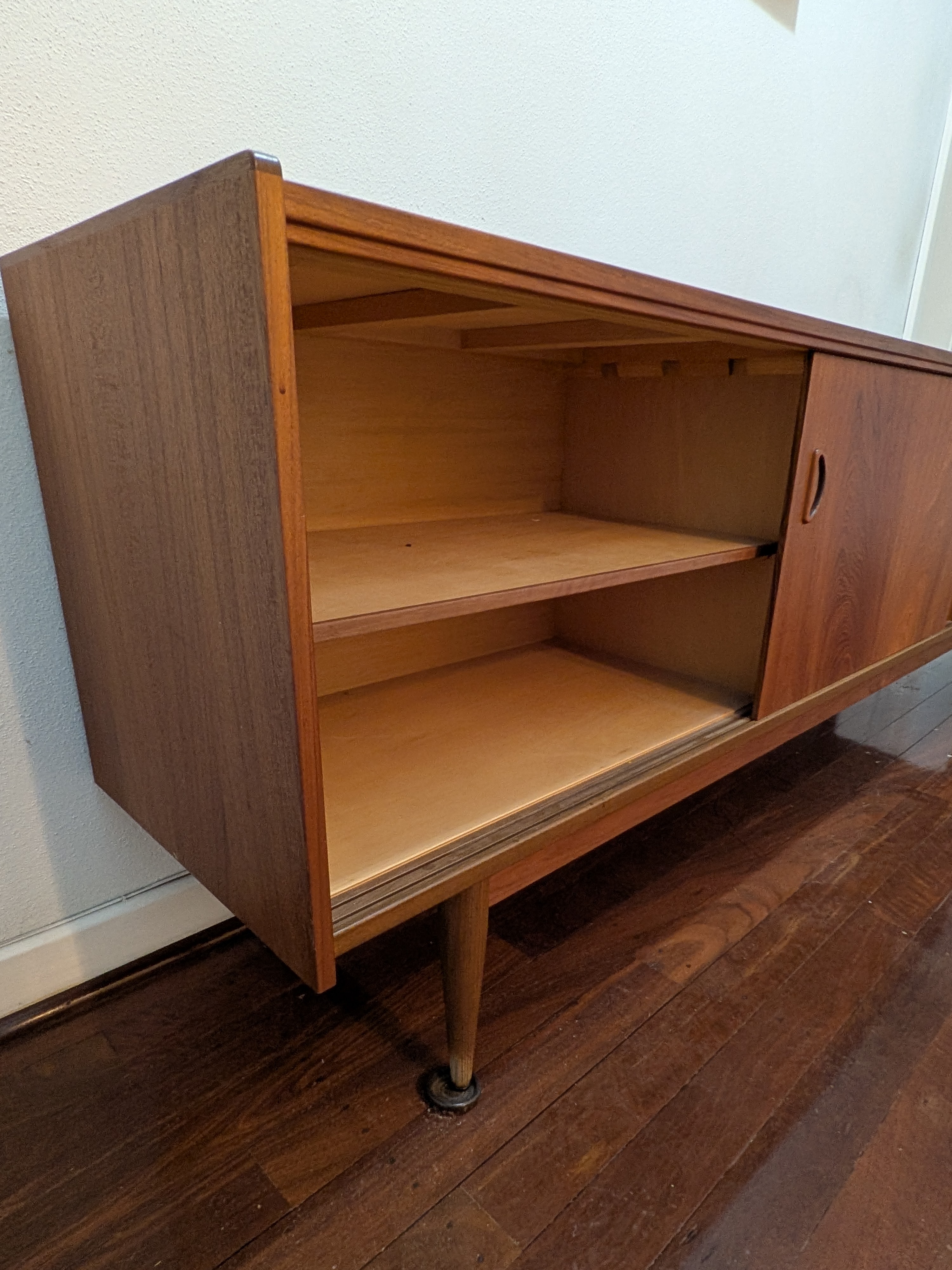 A classic Mid-Century Modern credenza, crafted from rich teak veneer with a warm, inviting tone, circa 1960s. This elegant piece features clean lines and functional design. - View 4