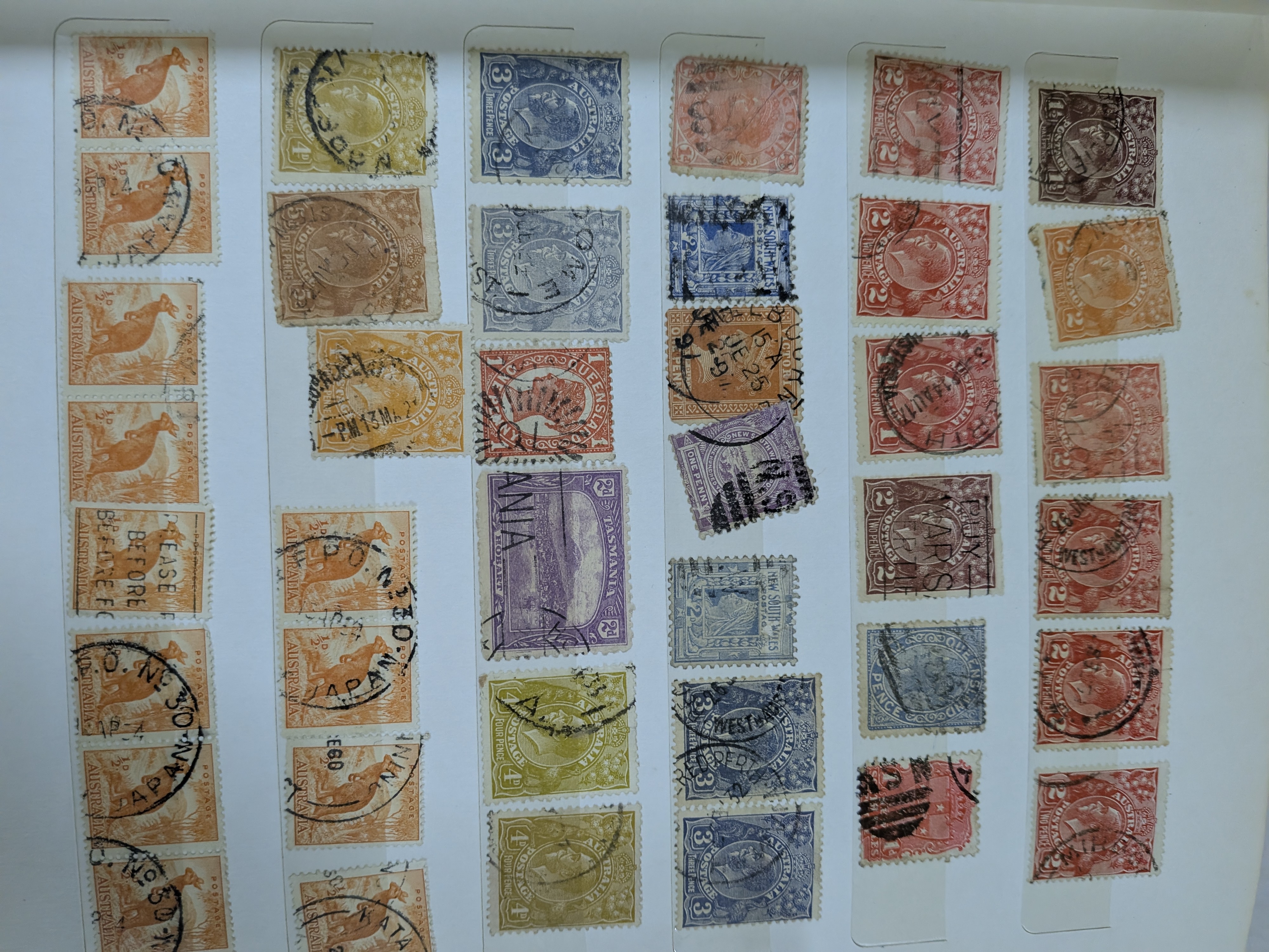 A vintage blue stamp album containing a diverse collection of Australian postage stamps from various periods. - View 4