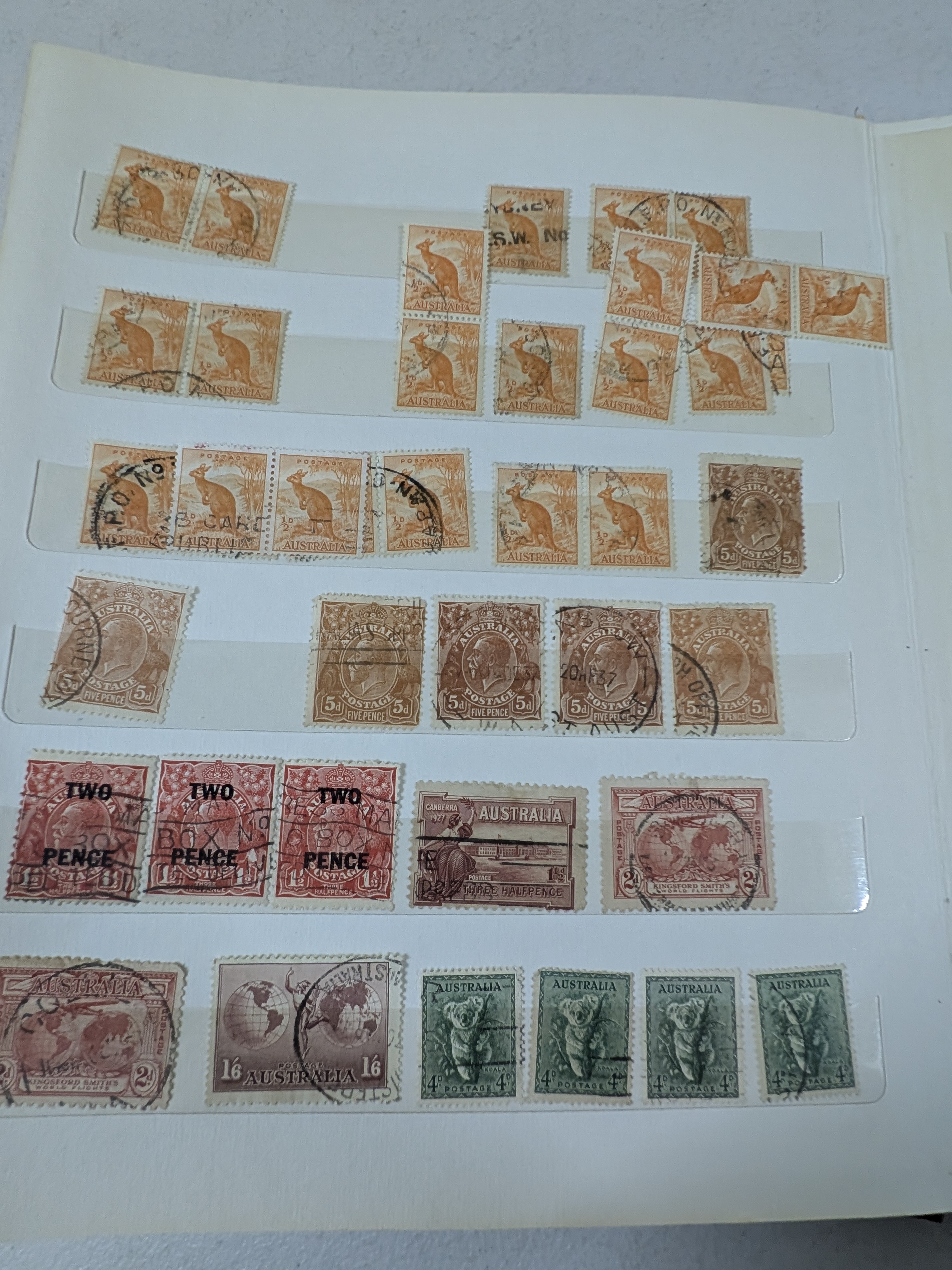 A vintage blue stamp album containing a diverse collection of Australian postage stamps from various periods. - View 6