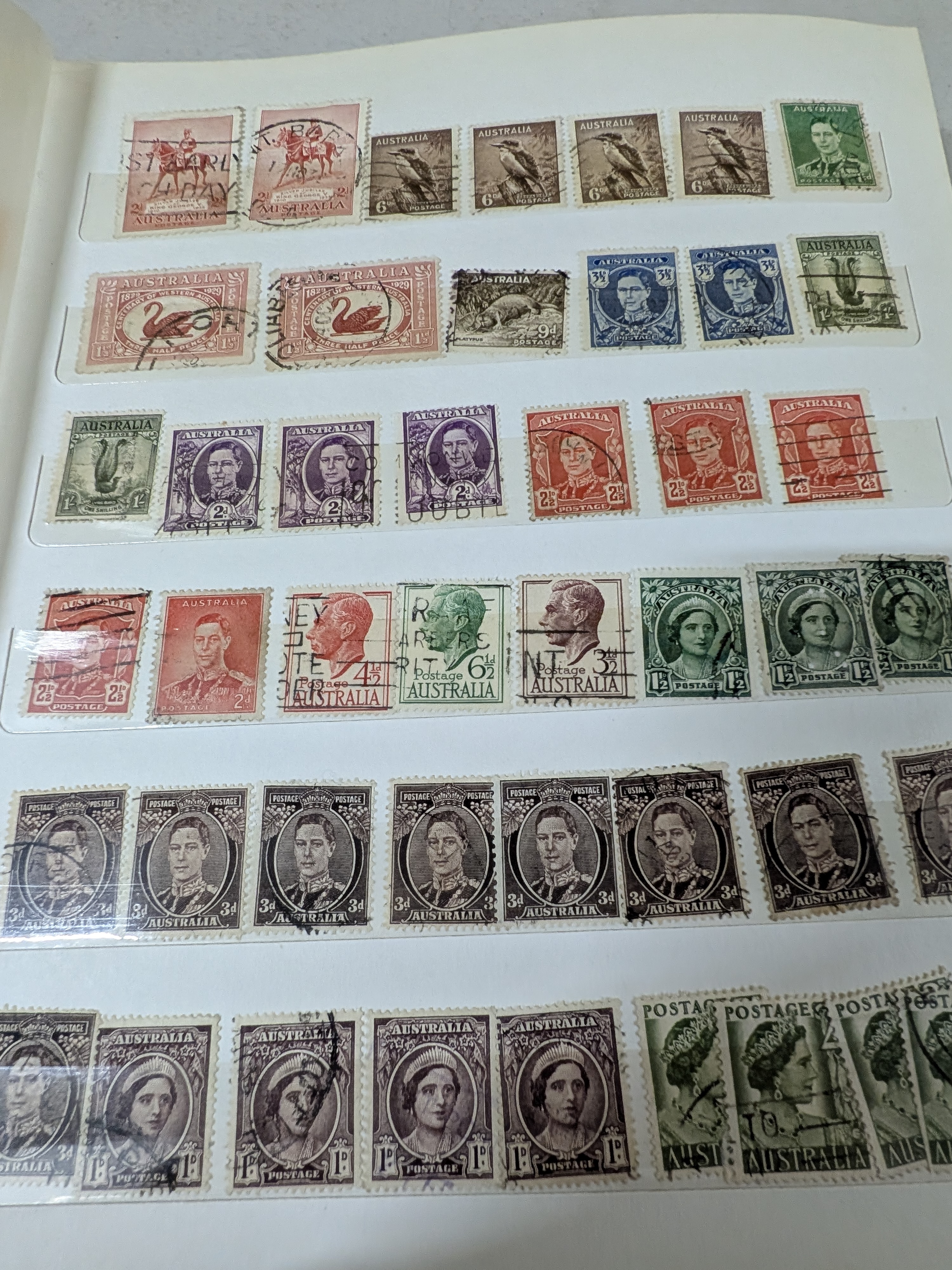 A vintage blue stamp album containing a diverse collection of Australian postage stamps from various periods. - View 7