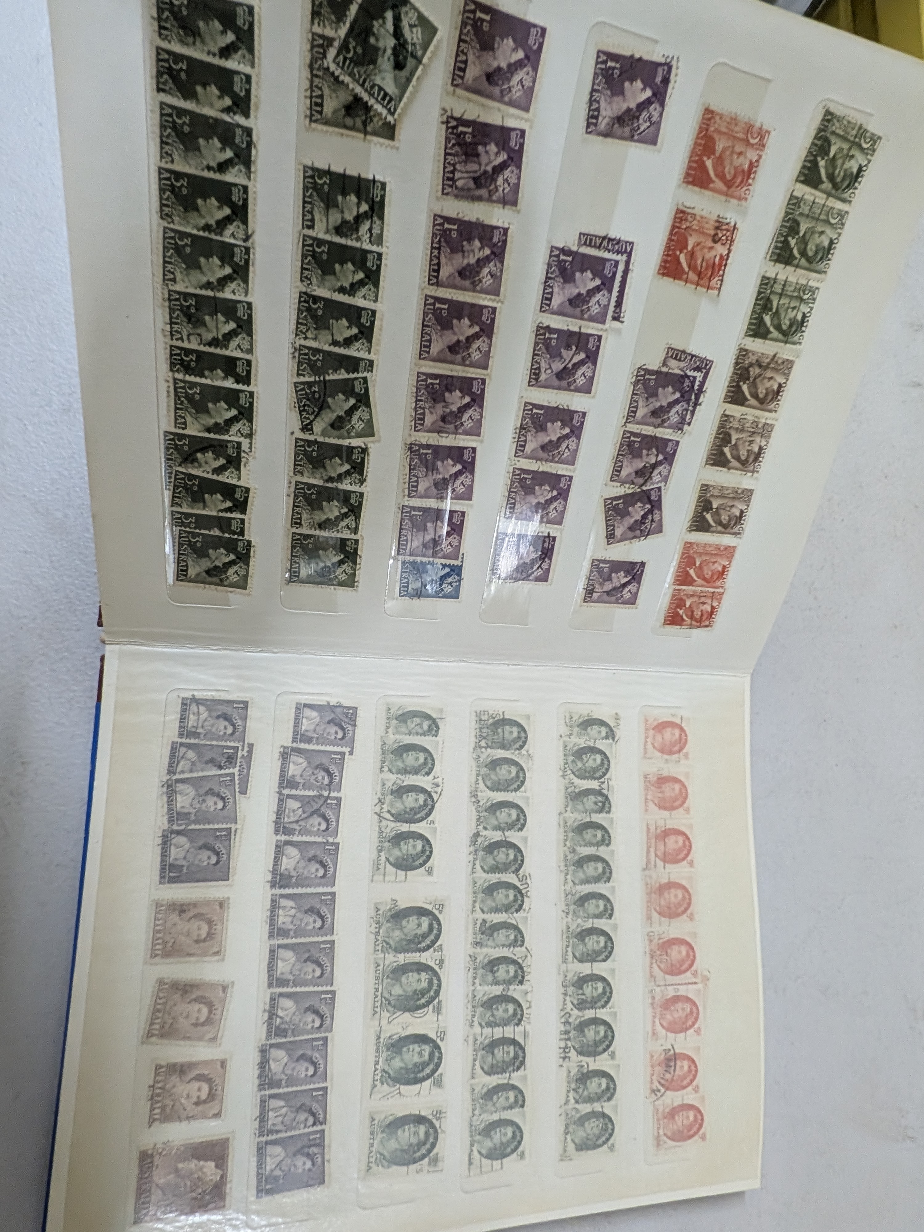 A vintage blue stamp album containing a diverse collection of Australian postage stamps from various periods. - View 8
