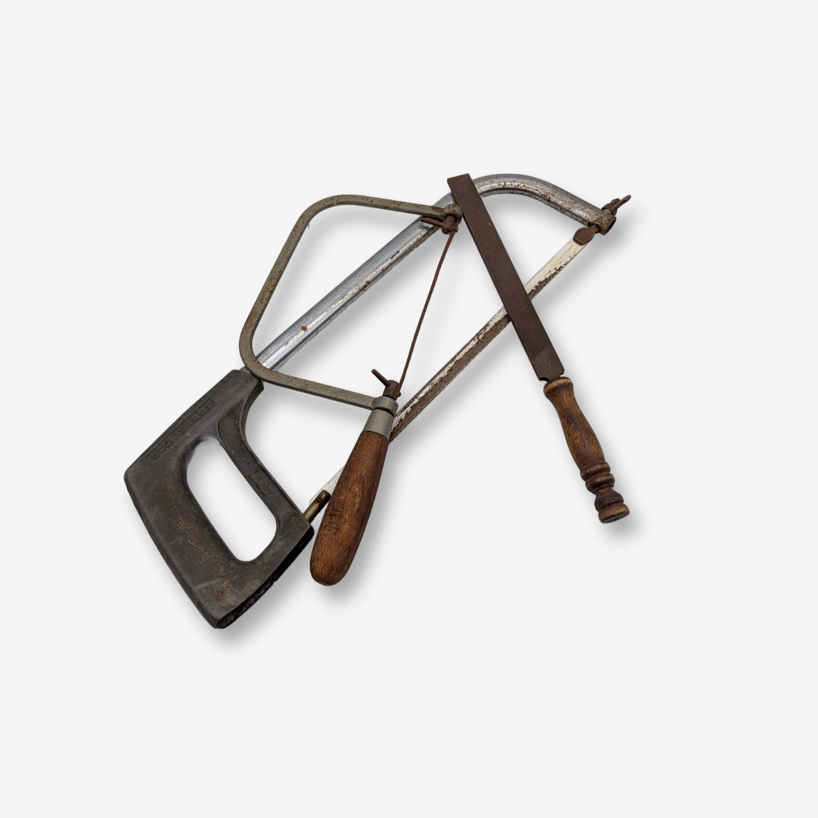 A collection of vintage Australian hand tools, including an Eclipse hacksaw, a bow saw, and a Wiltshire file, all showing significant signs of age and use.