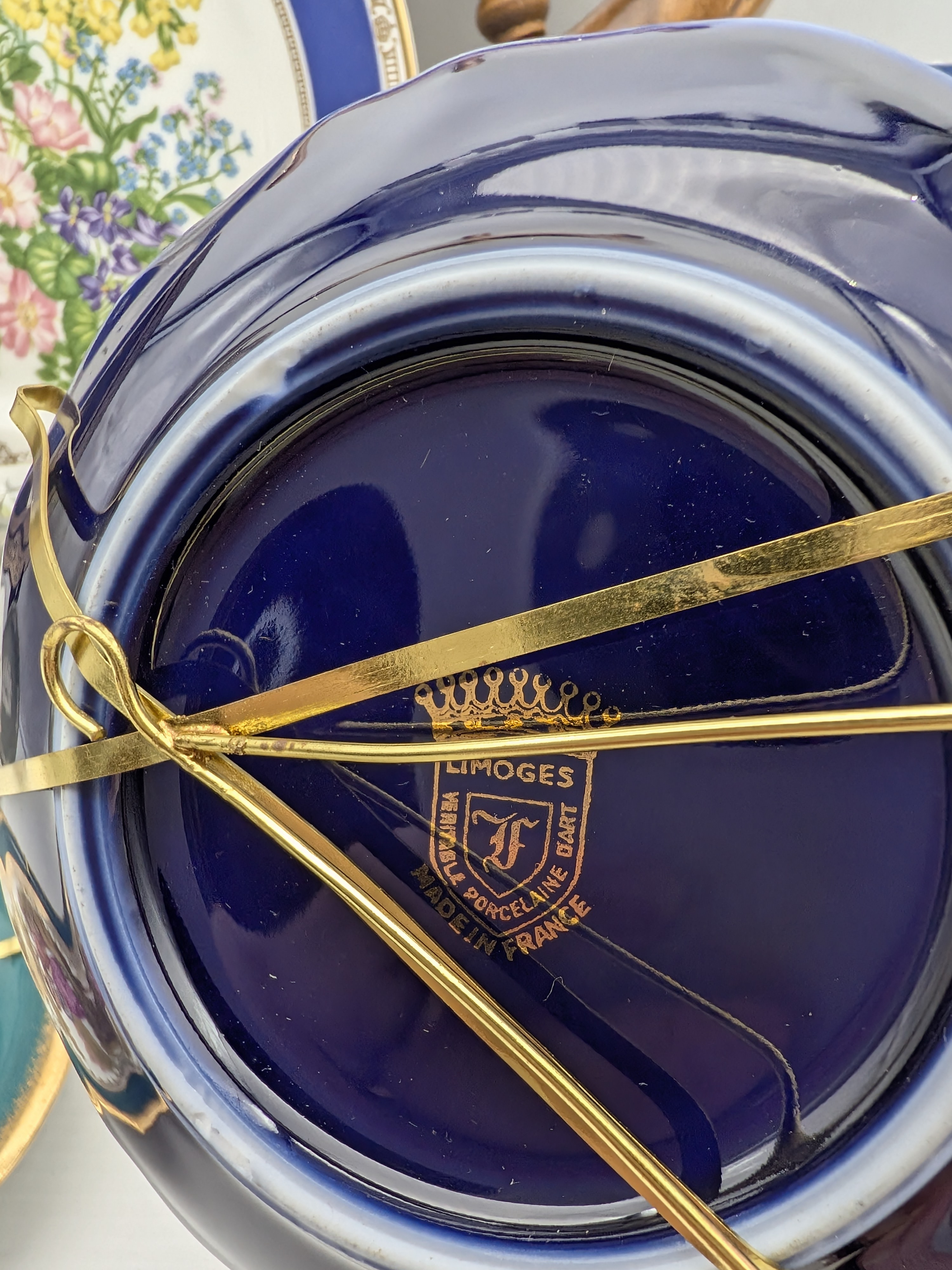 A diverse collection of vintage homewares and decorative sundries, including ceramic plates, a Greek-style amphora with lid, and a nautical-themed barometer/thermometer on a ship's wheel. - View 6