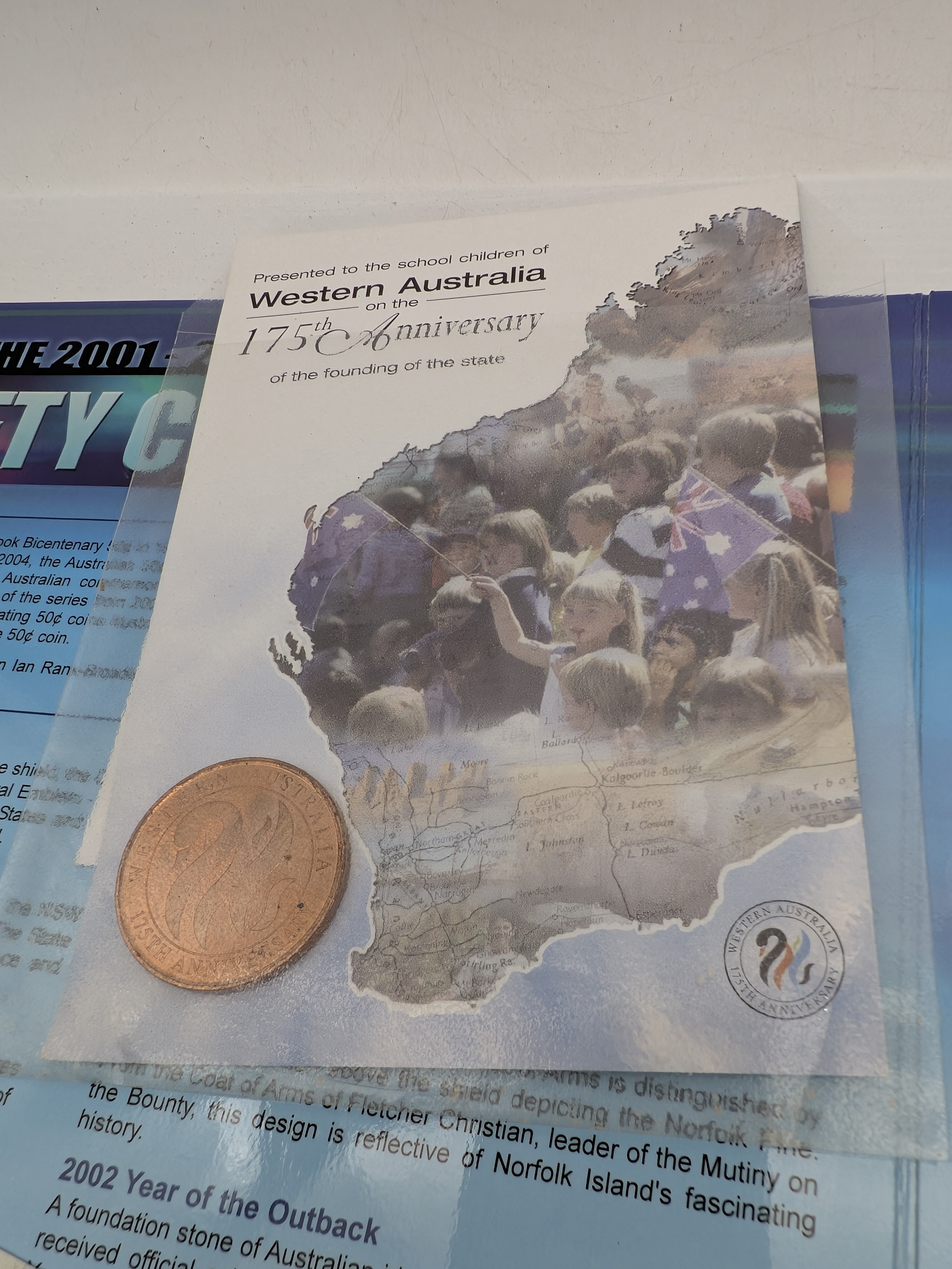 An Australian coin collection featuring a 2001-2004 fifty cent coin folder, a commemorative Western Australian 2 cent coin, and a 2004 Eureka Stockade one dollar uncirculated coin. - View 3