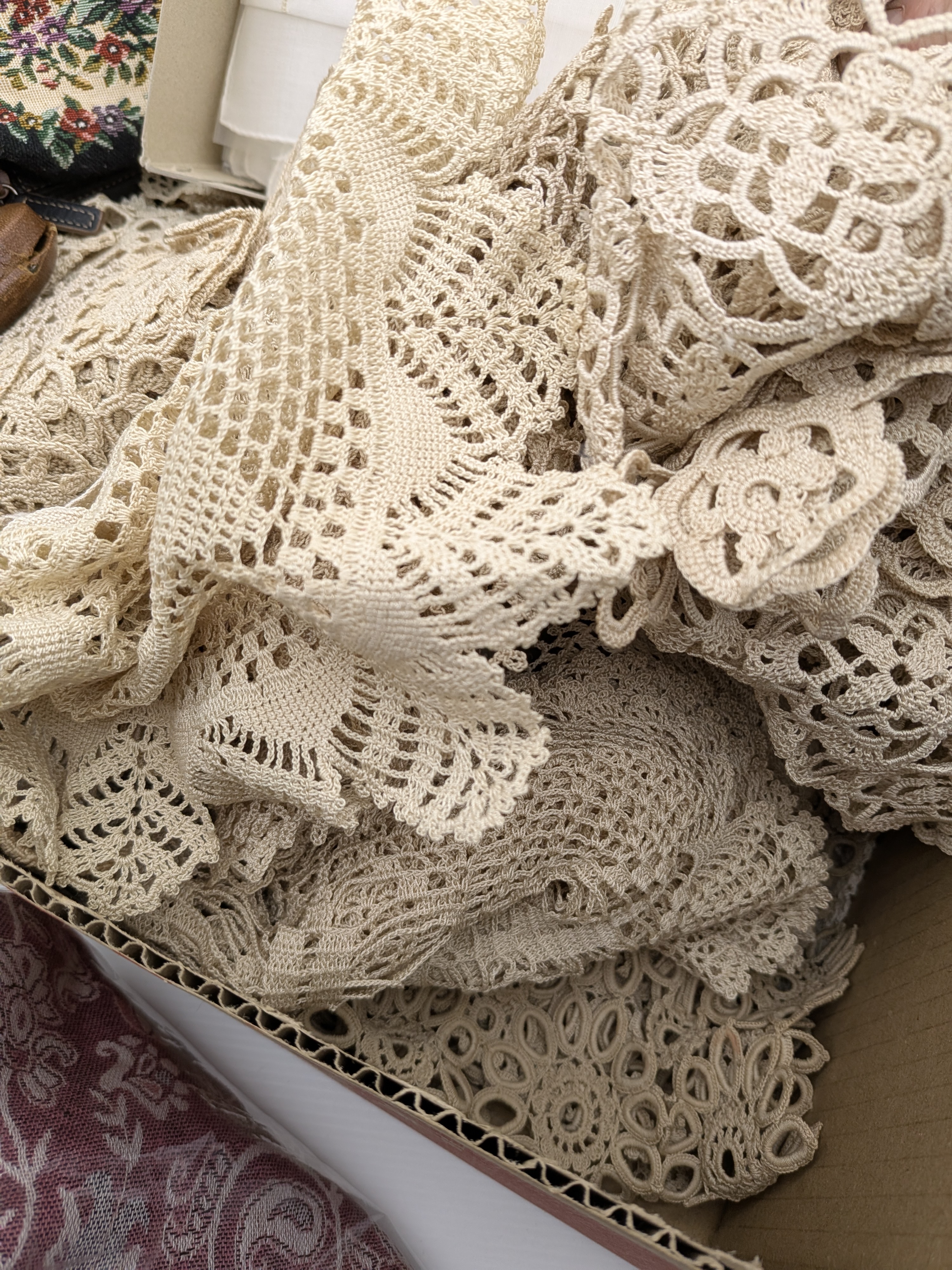 A diverse collection of vintage and contemporary household and personal accessories, including textile goods such as embroidered handkerchiefs, a pure pashmina shawl, and a quantity of crocheted lace, alongside several small leather and fabric purses and a spectacle case. - View 7