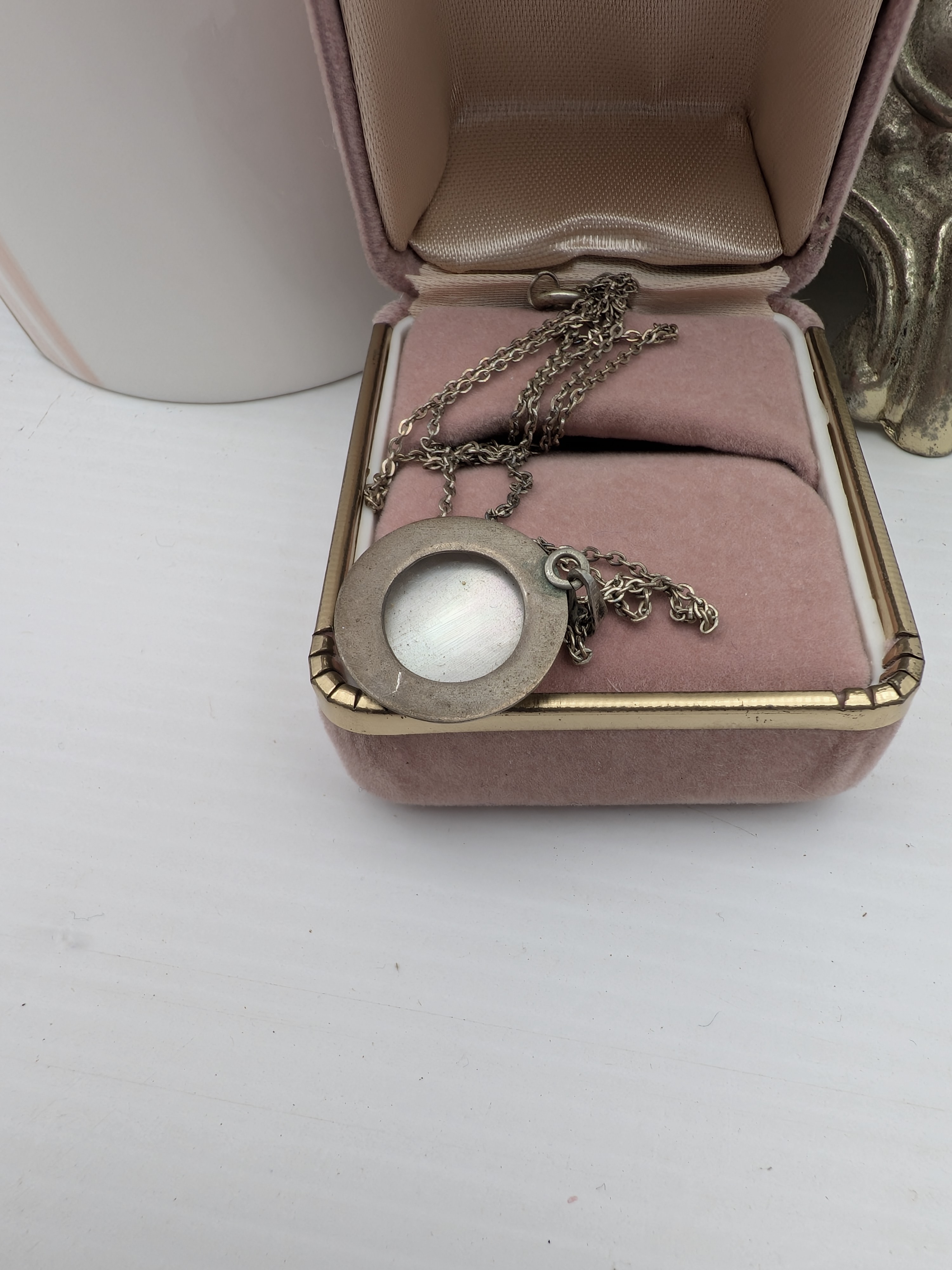 A charming collection of vintage decorative items, including a red art glass vase, a ceramic vase, a small hobnail glass table lamp, and a velvet jewellery box containing a silver-toned cameo necklace. - View 3